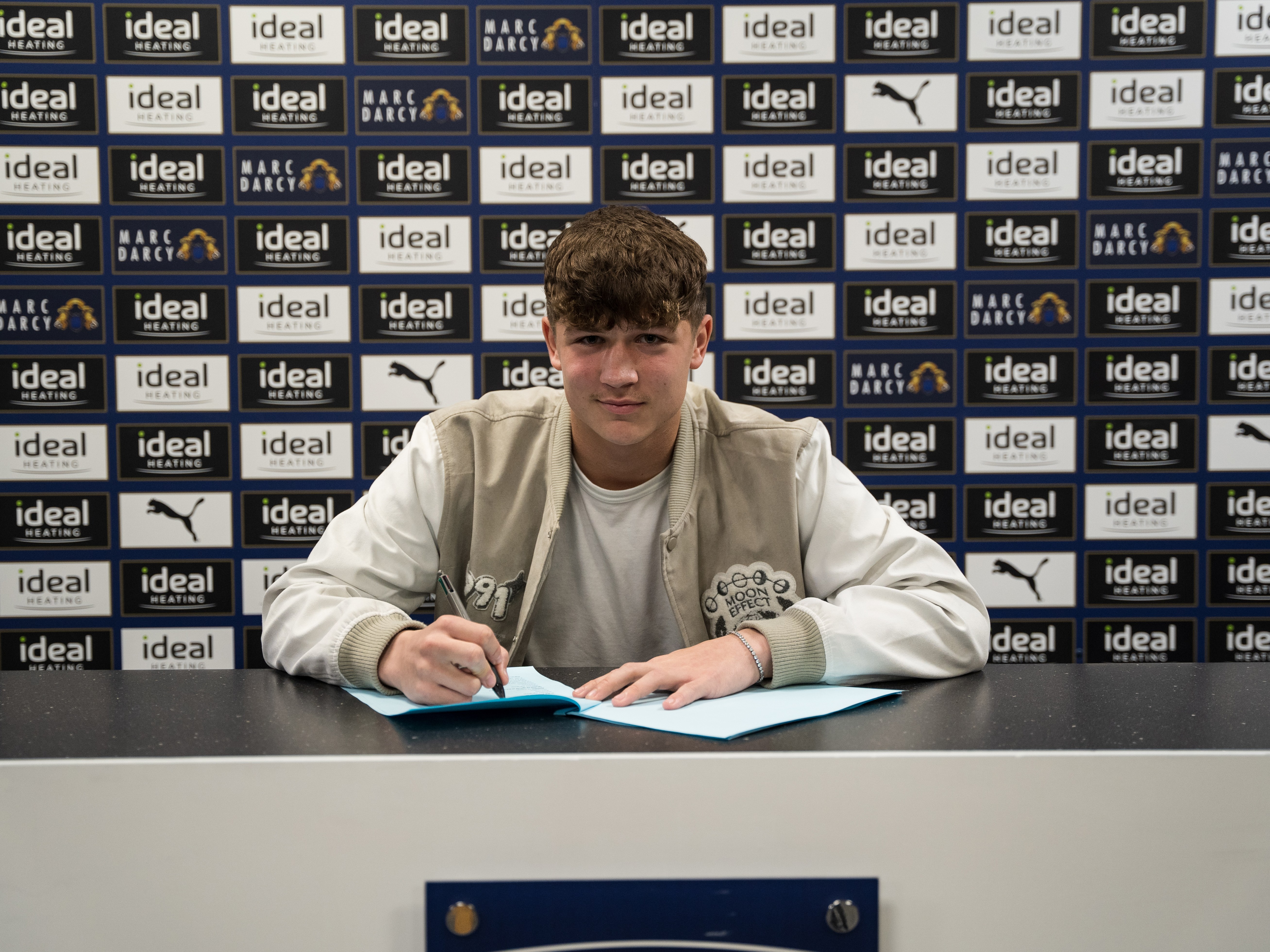 A photo of Albion youngster Cole Deeming signing pro terms at the training ground