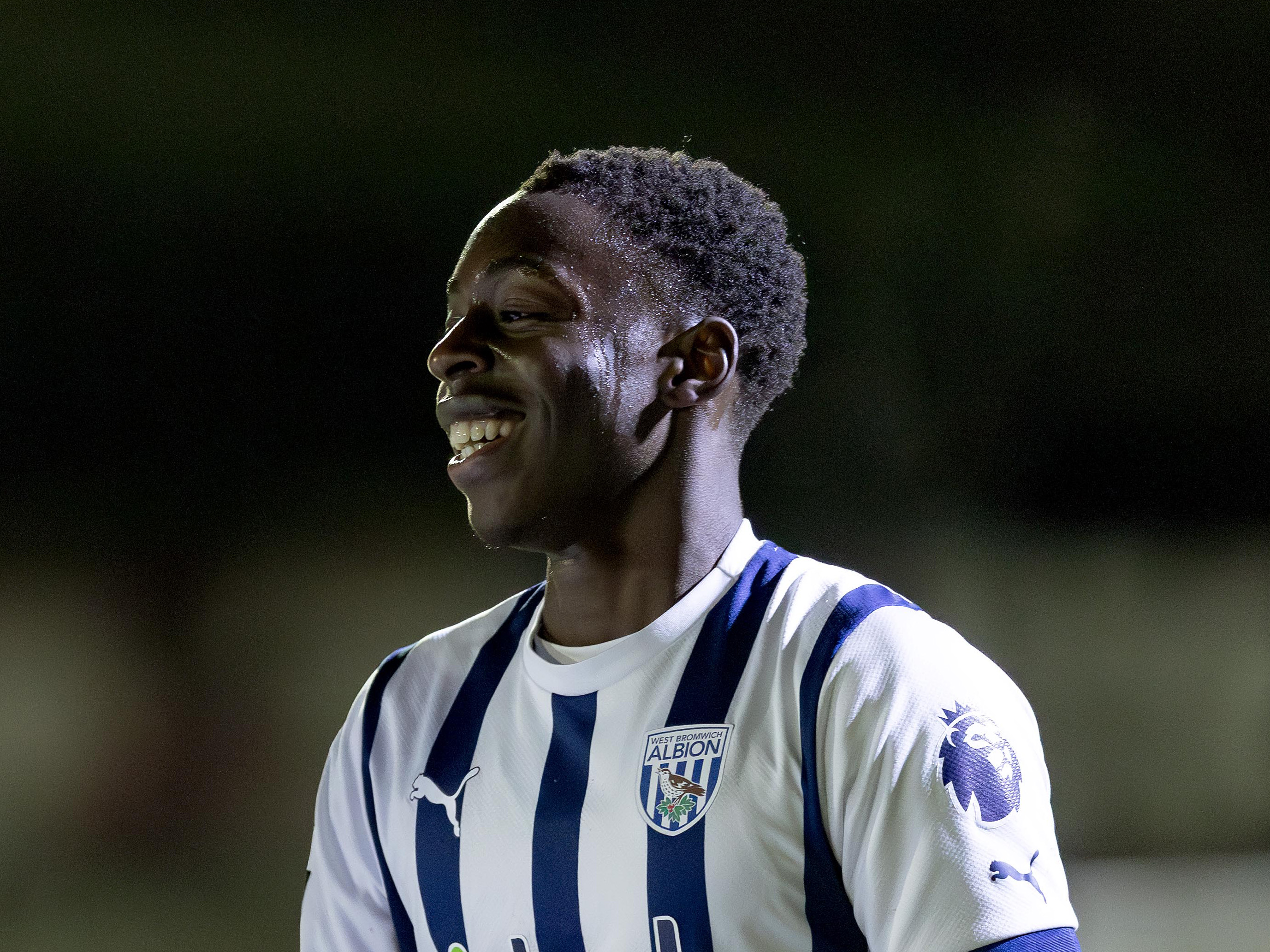 A photo of Albion academy striker Eseosa Sule smiling in the 23/24 home kit
