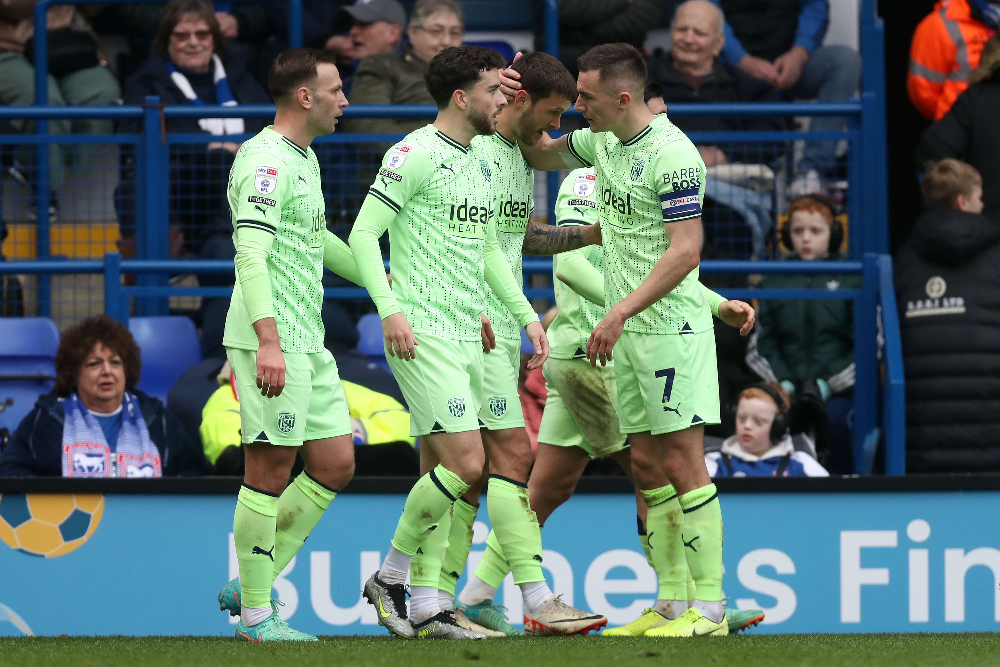 Albion players celebrate with John Swift after his goal at Portman Road against Ipswich while wearing the lime green away kit