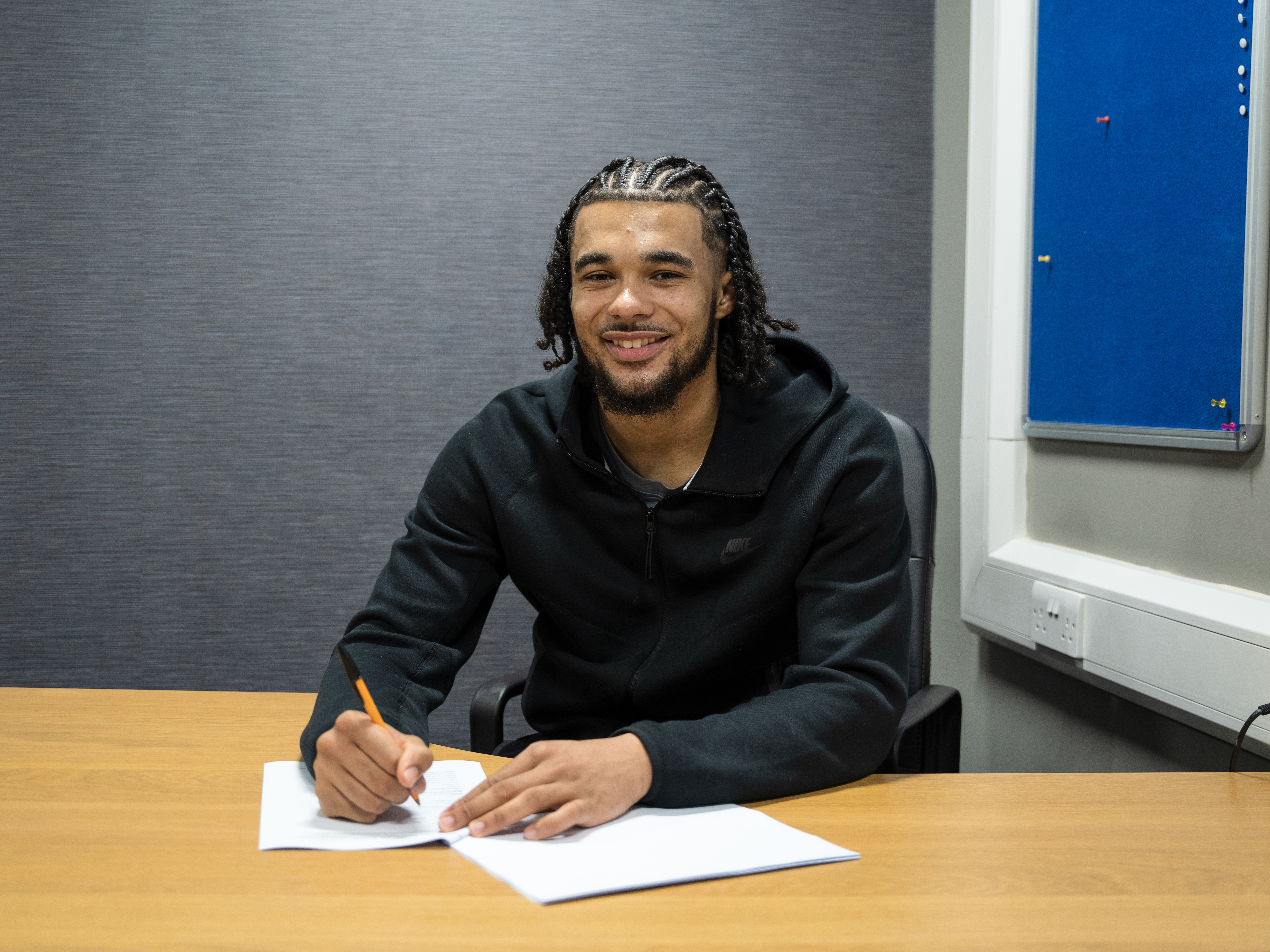 A photo of Jamal Mohammed signing professional terms