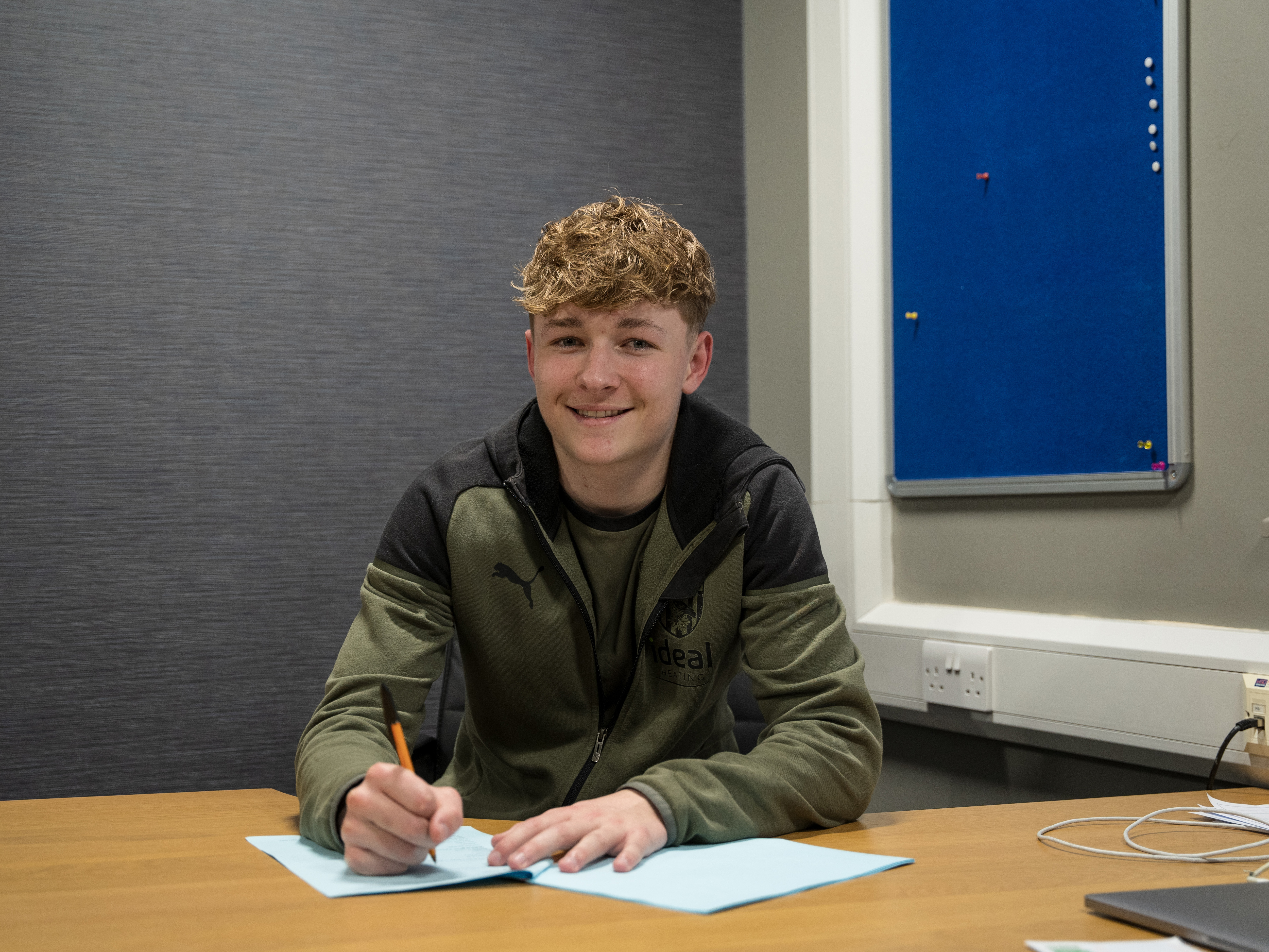 A photo of Ollie Bostock signing professional terms with the club