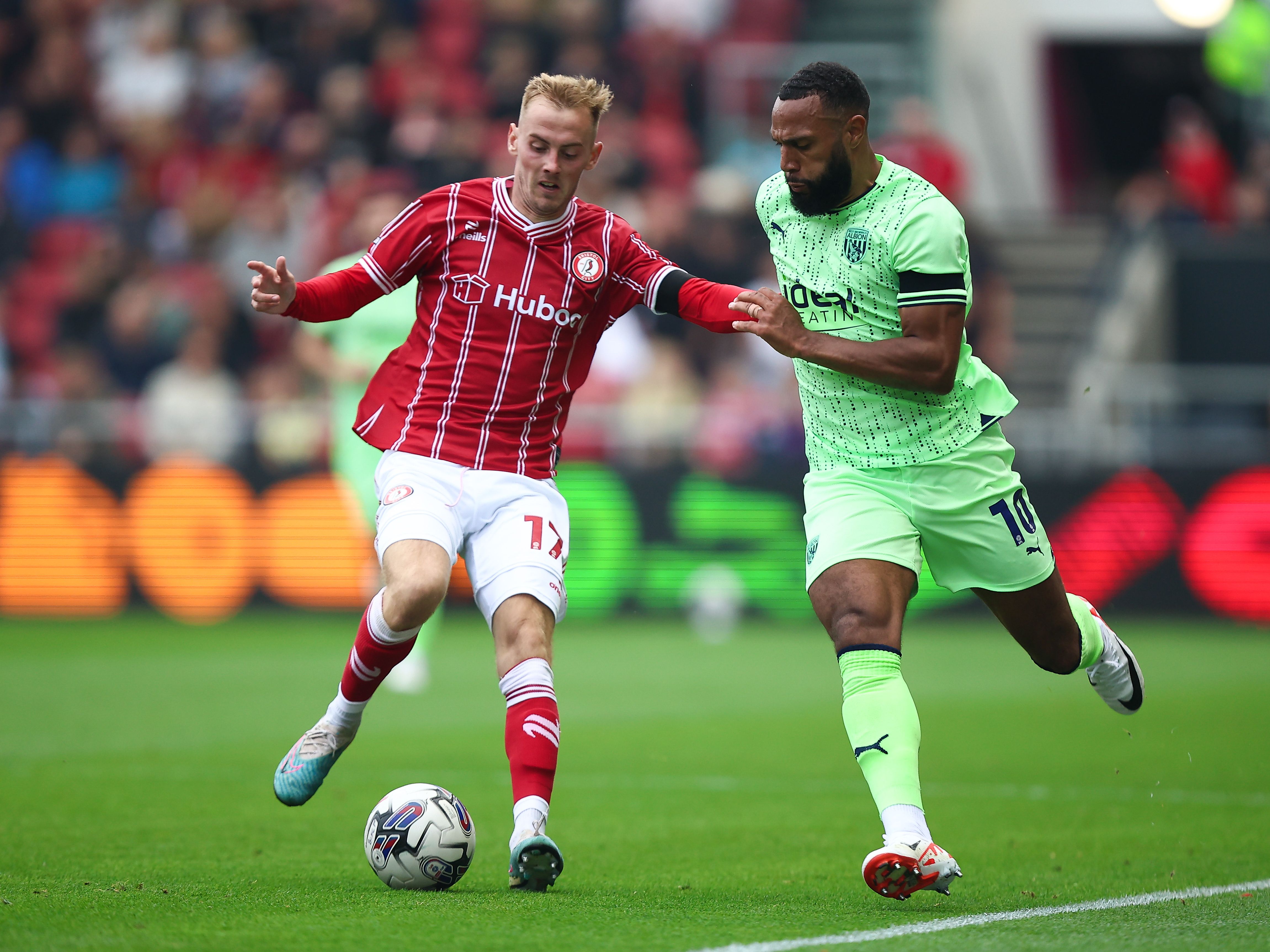 Matty Phillips battles for the ball with a Bristol City player at Ashton Gate while wearing the lime green away kit