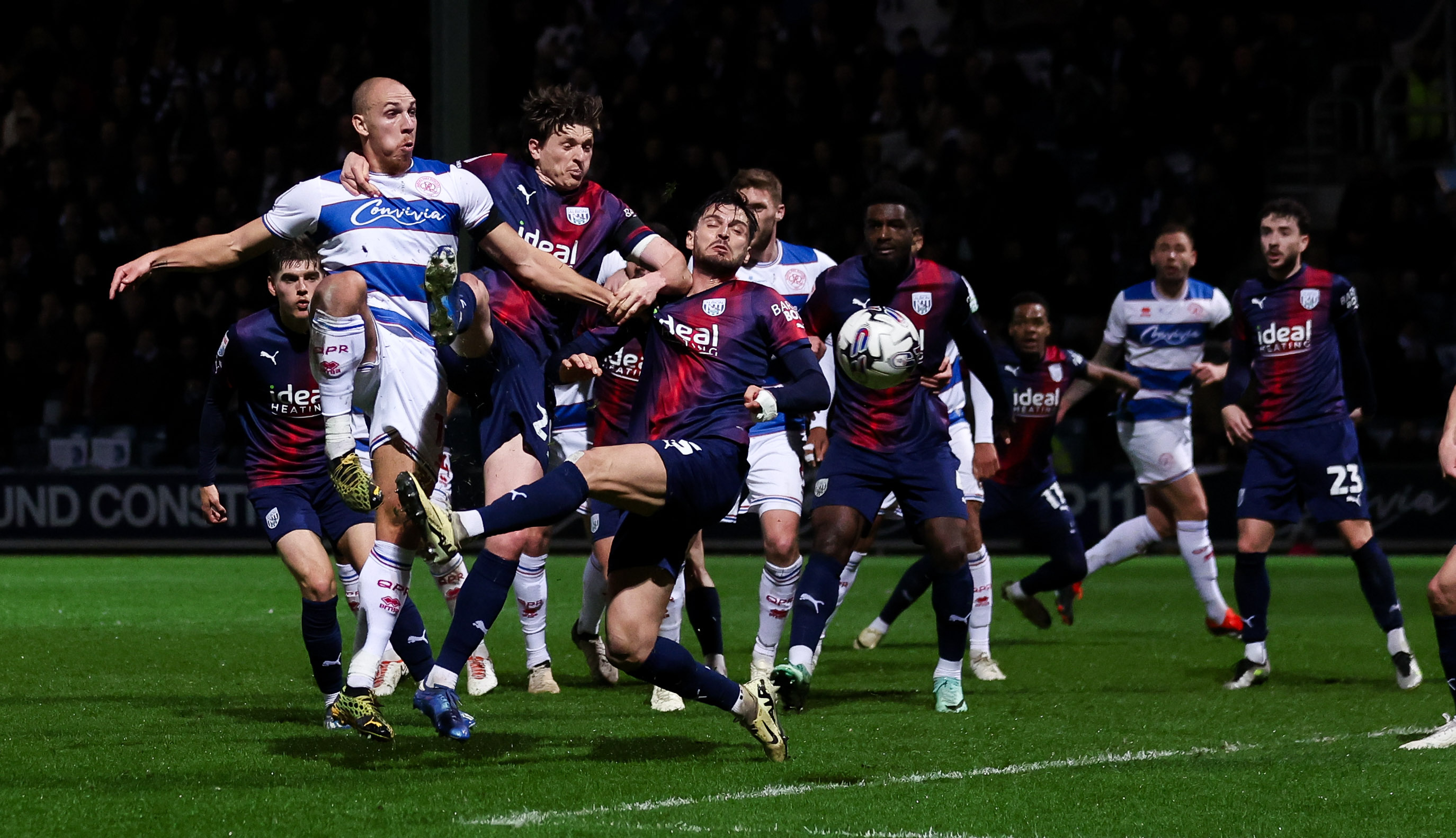 QPR and WBA players fight for the ball in the box