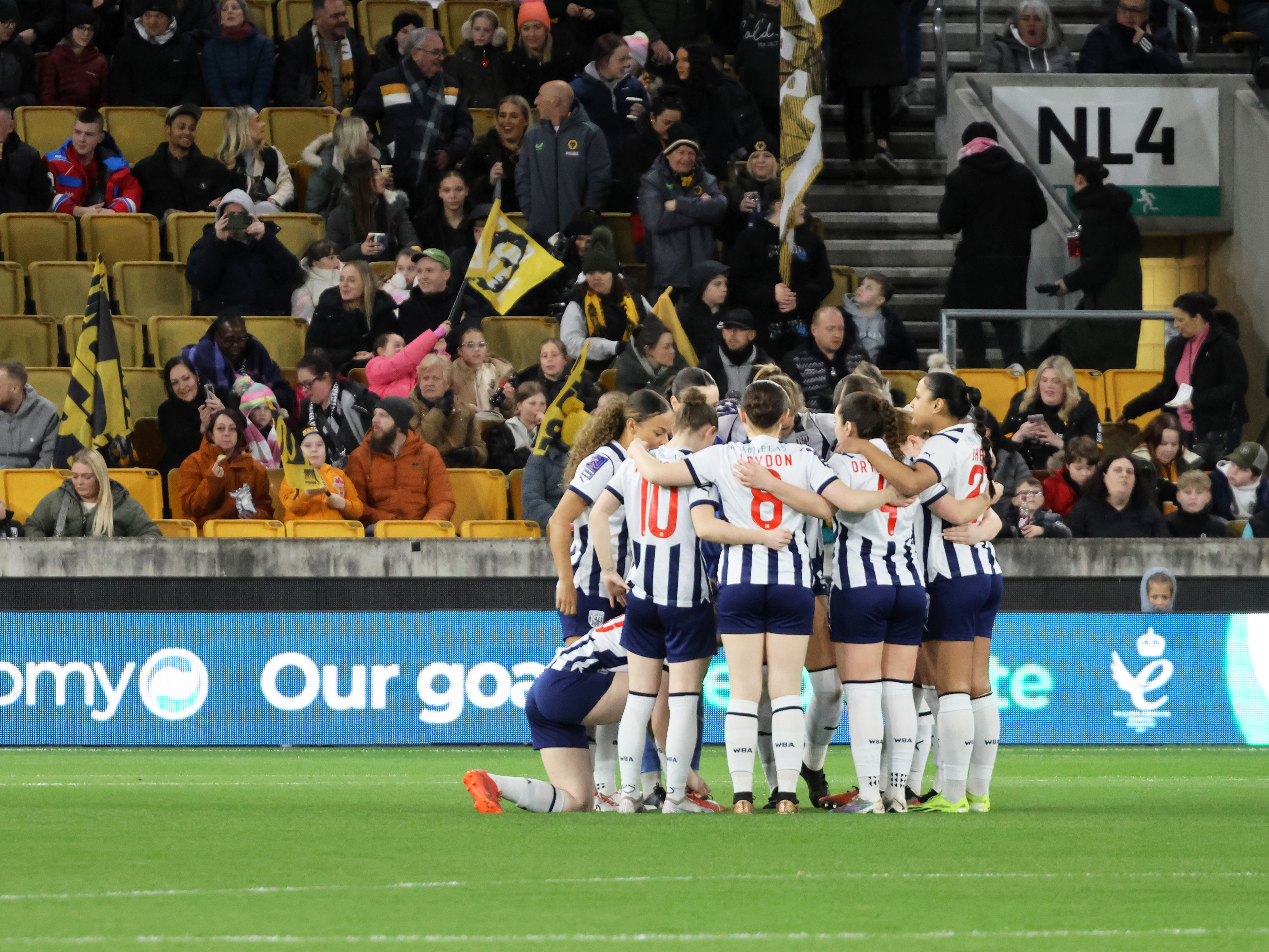 An image showing Albion Women in a team huddle at Molineux