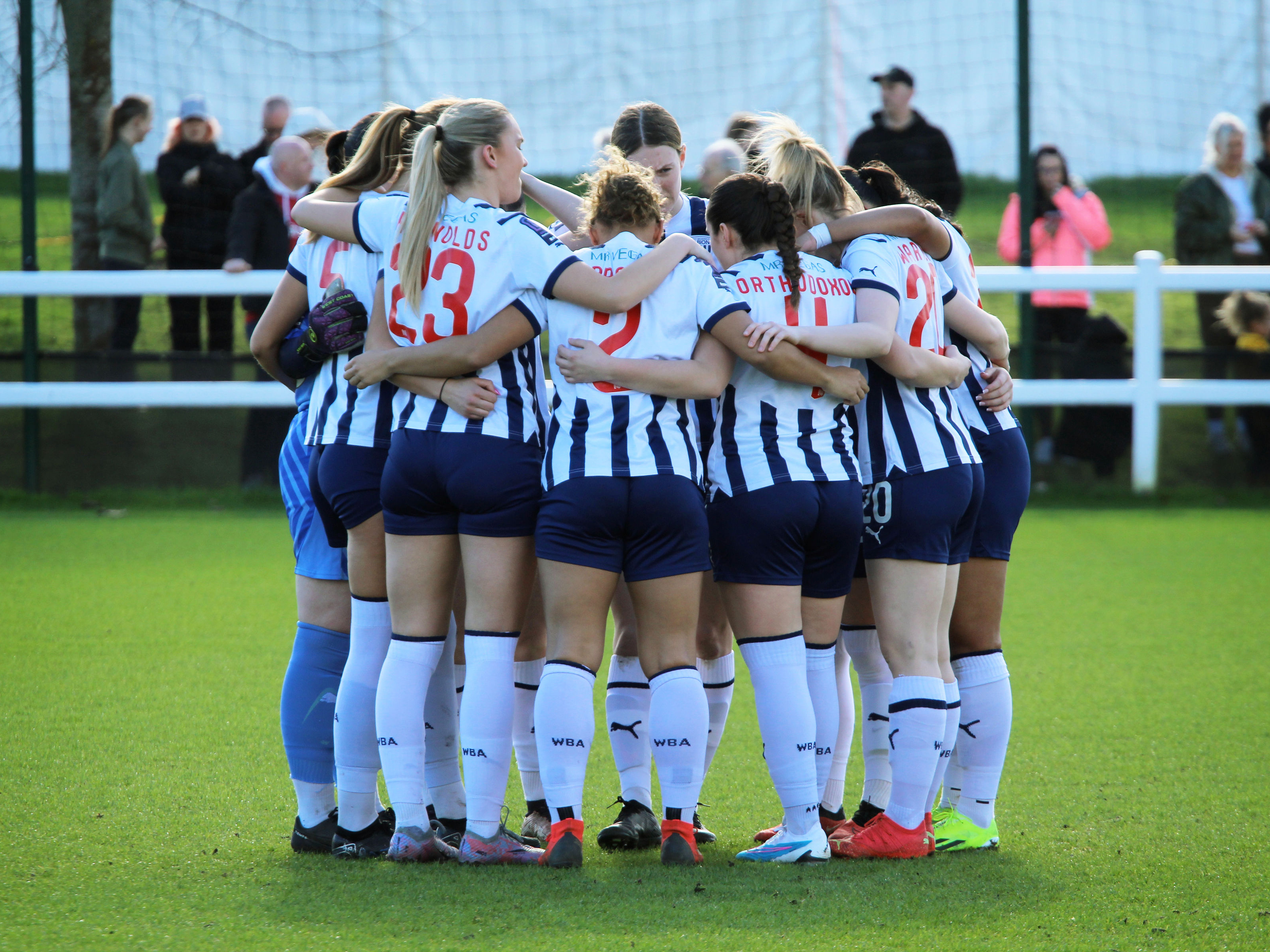 An image of Albion Women in a team huddle
