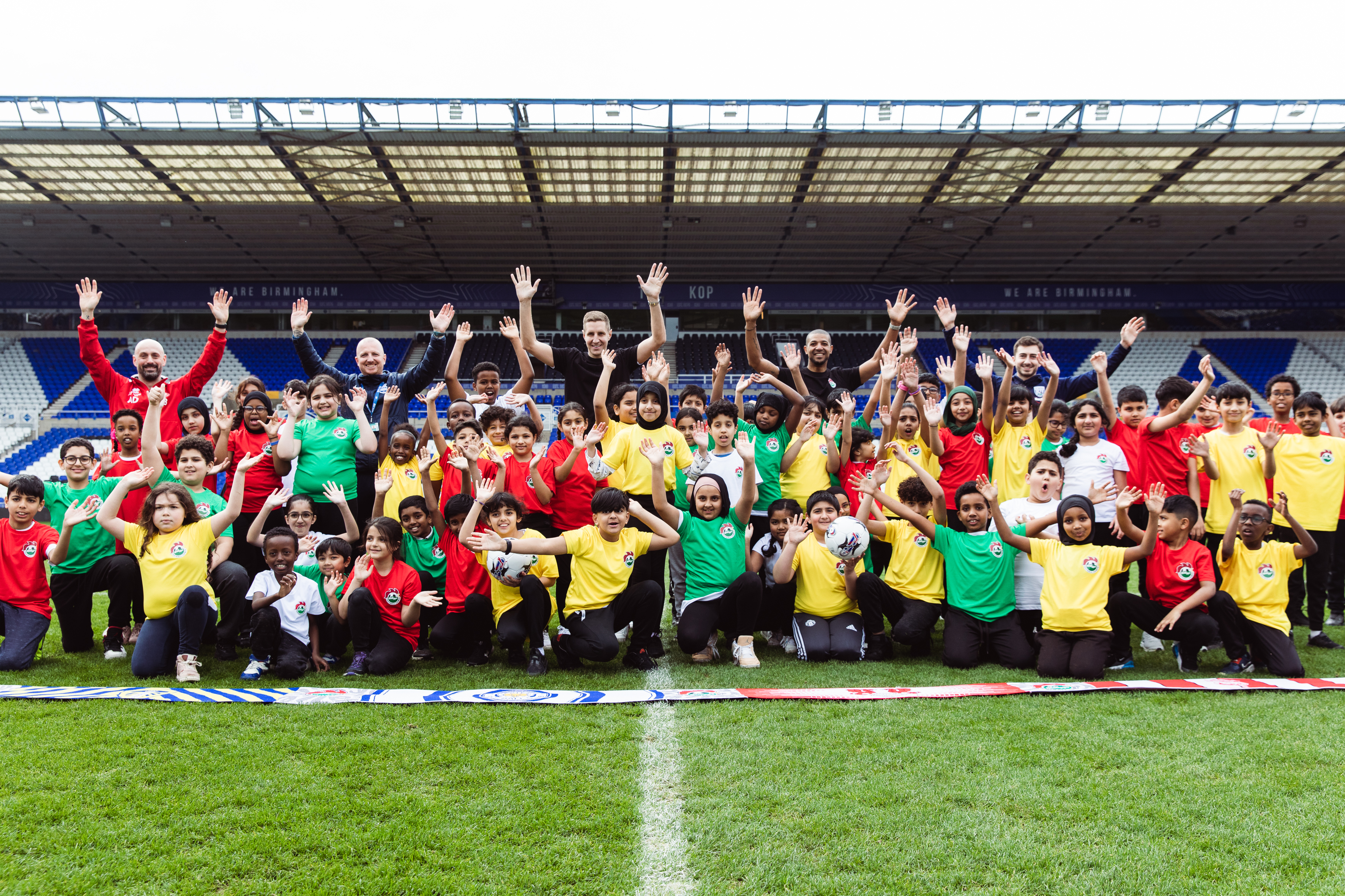 Group photos of children, players & mascots cheering with hands in the air.