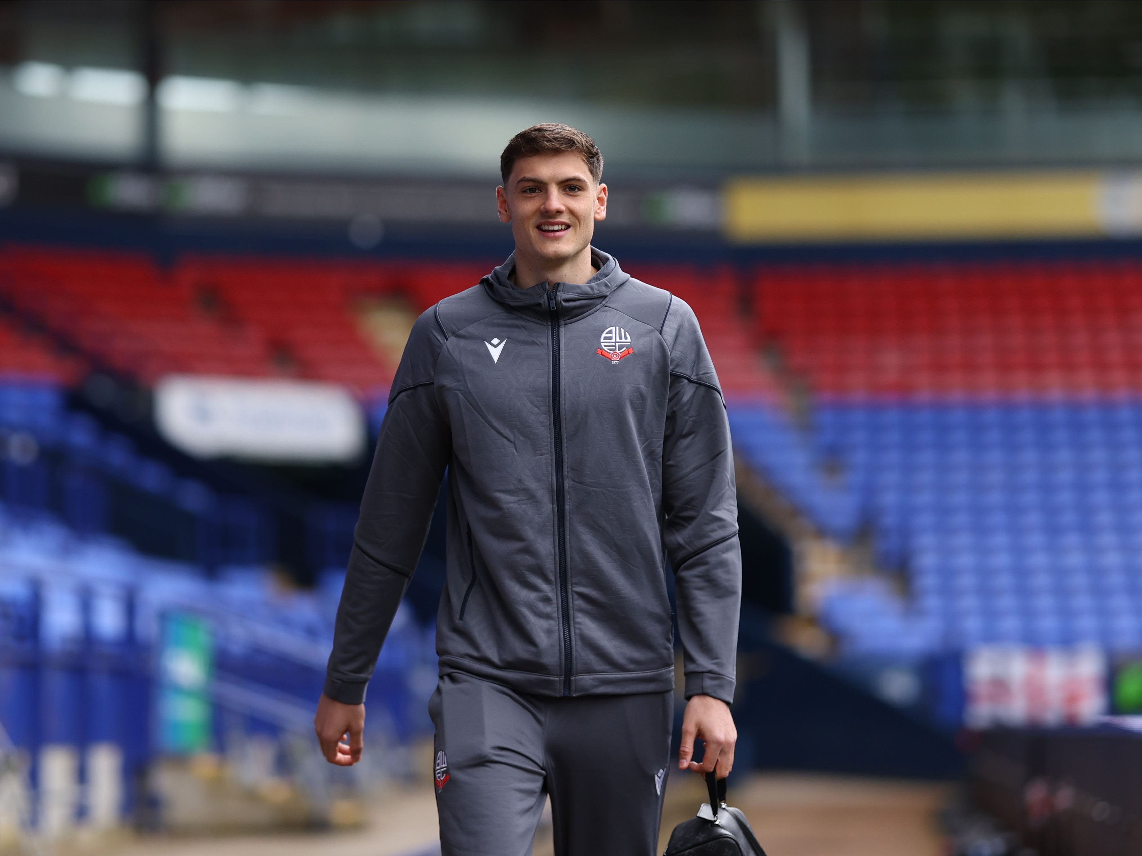 A photo of Caleb Taylor arriving at the Toughest Community Stadium, wearing loan club Bolton Wanderers' tracksuit wear