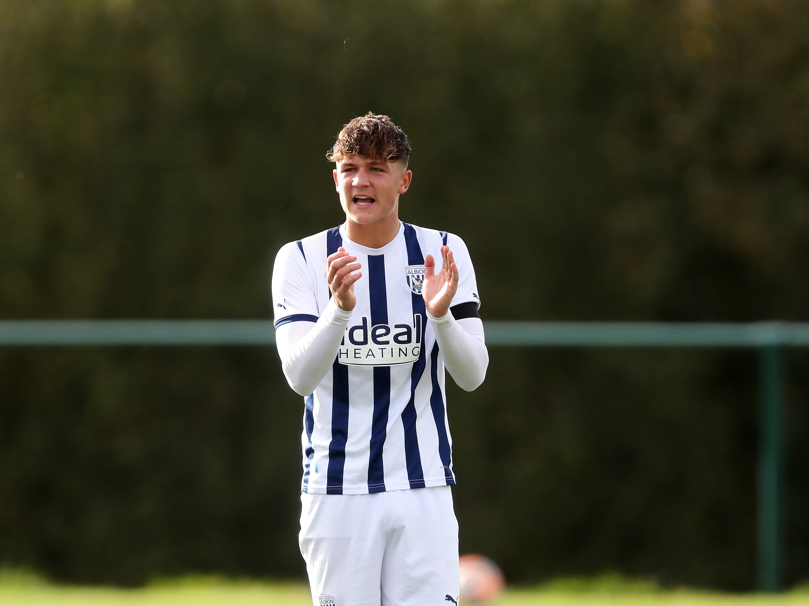 Cole Deeming clapping his hands wearing the home kit in action for Albion's U18 side