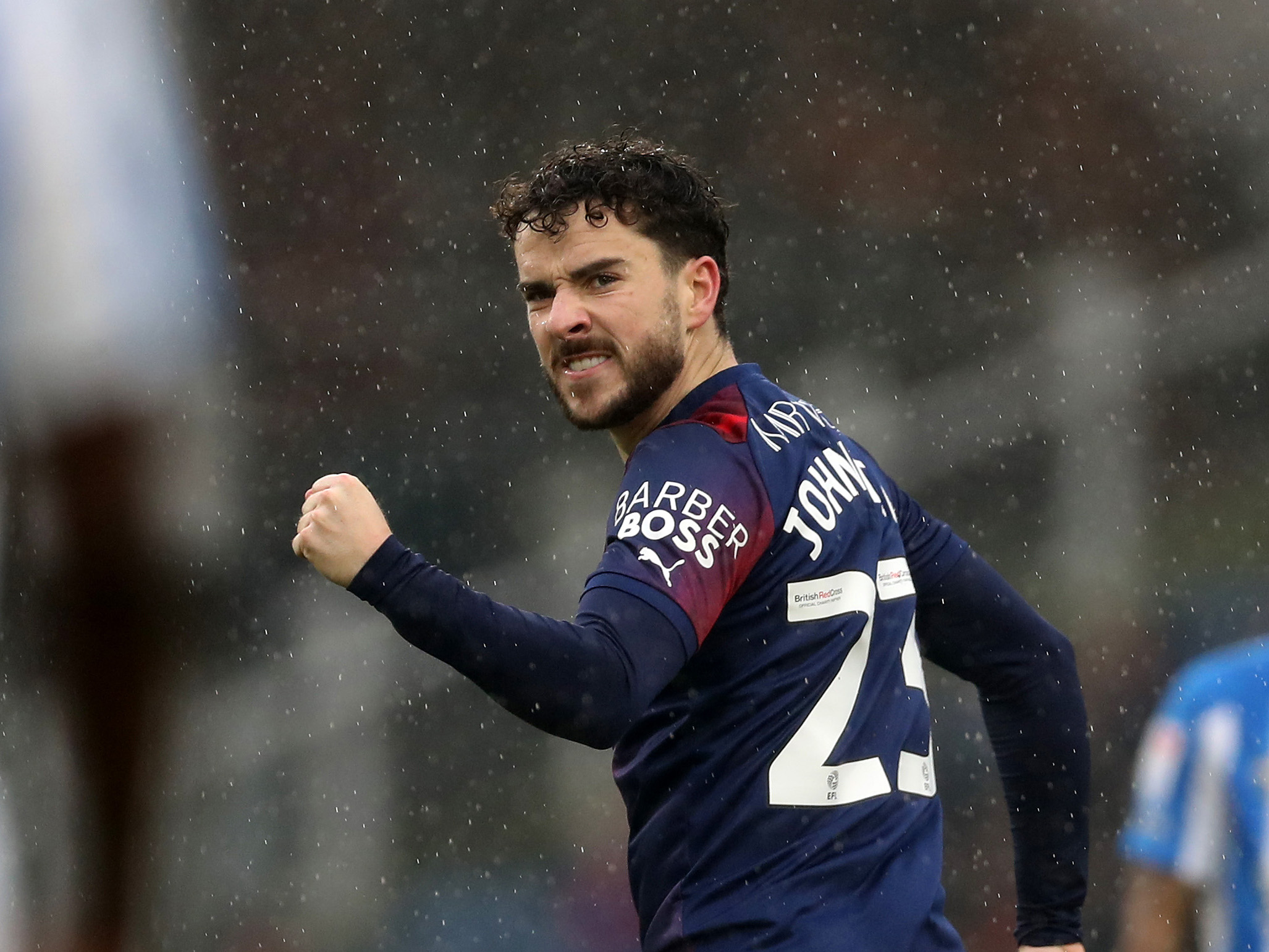 Mikey Johnston celebrates scoring against Huddersfield while wearing Albion's navy blue and red kit