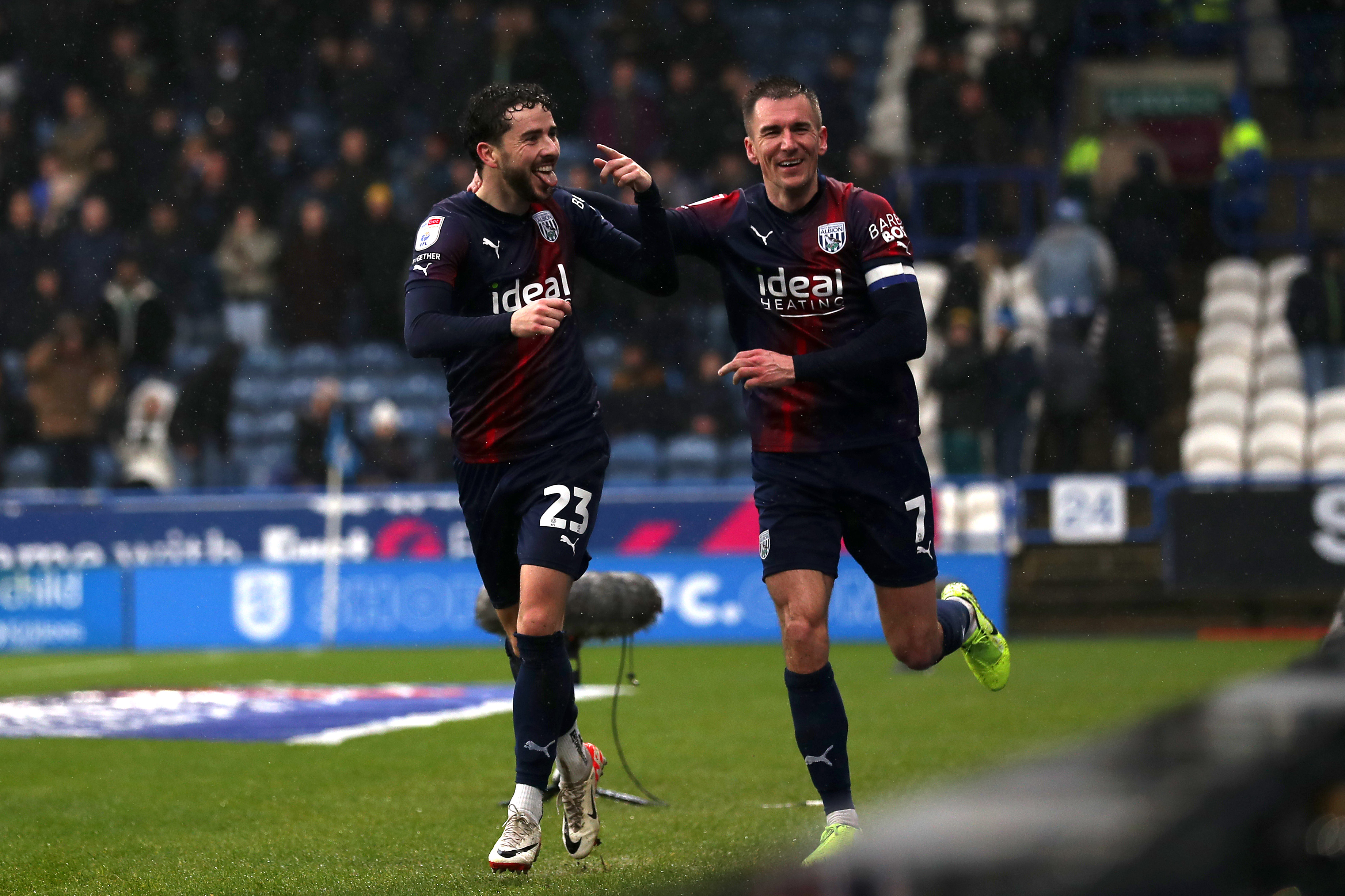 Mikey Johnston celebrates scoring against Huddersfield with Jed Wallace while wearing the navy-blue-and-red away kit