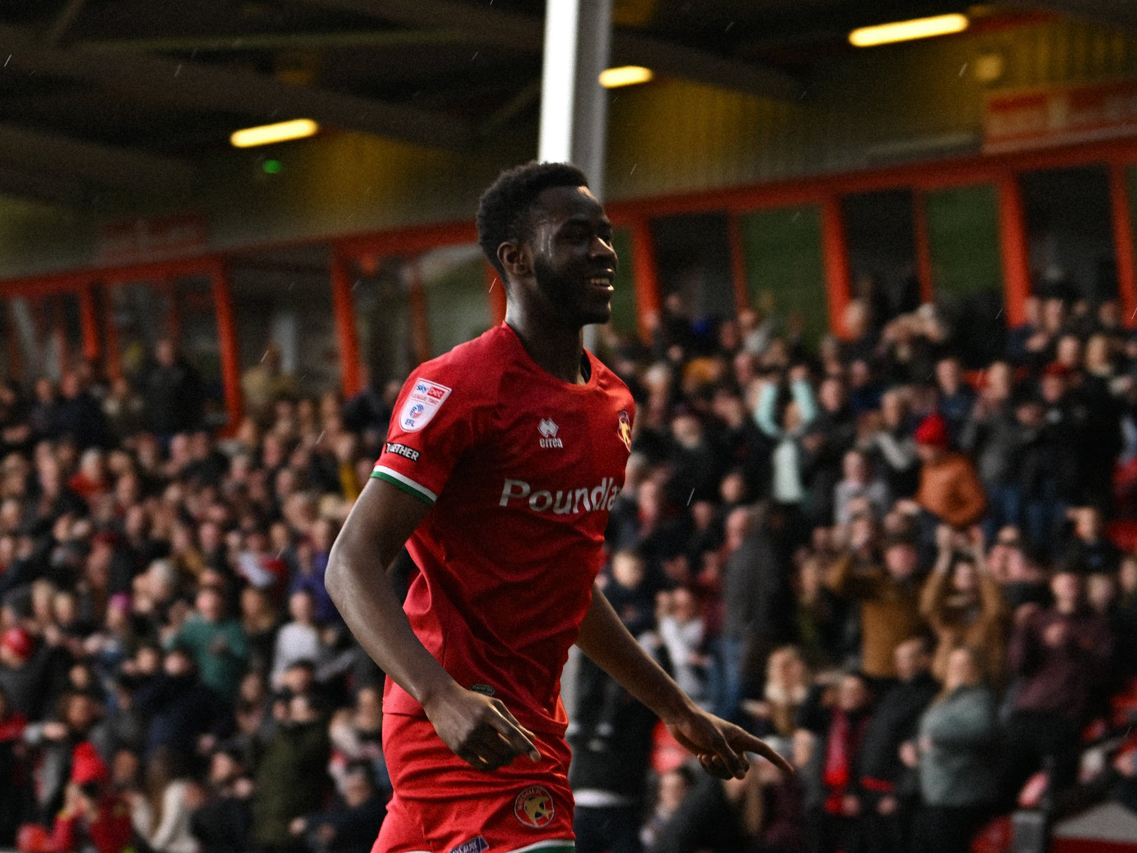 Mo Faal celebrates scoring for Walsall while wearing their home shirt 