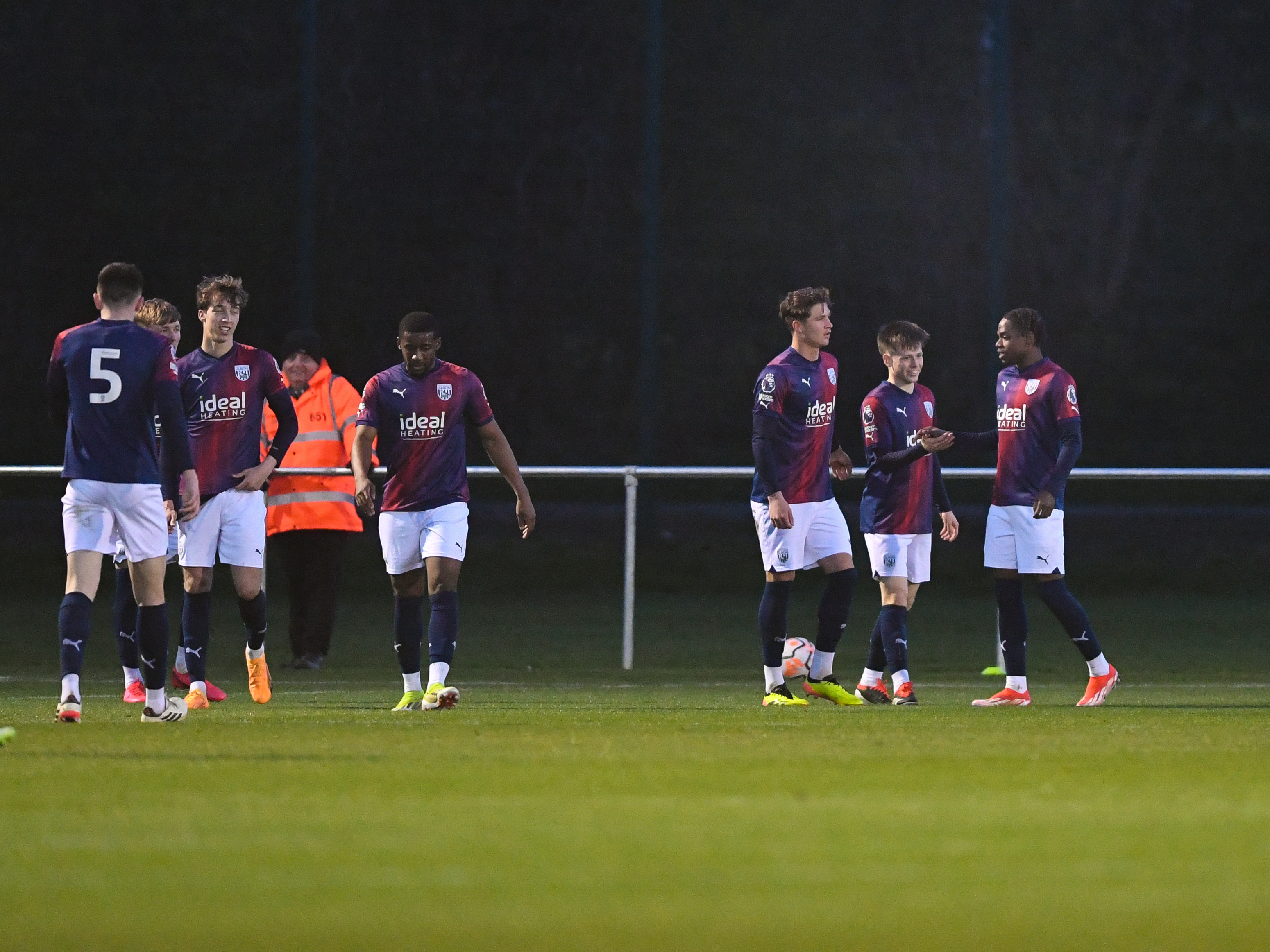 A photo of Fenton Heard and Albion's PL2 team, wearing the red and blue 23/24 away kit, celebrating a goal against Newcastle