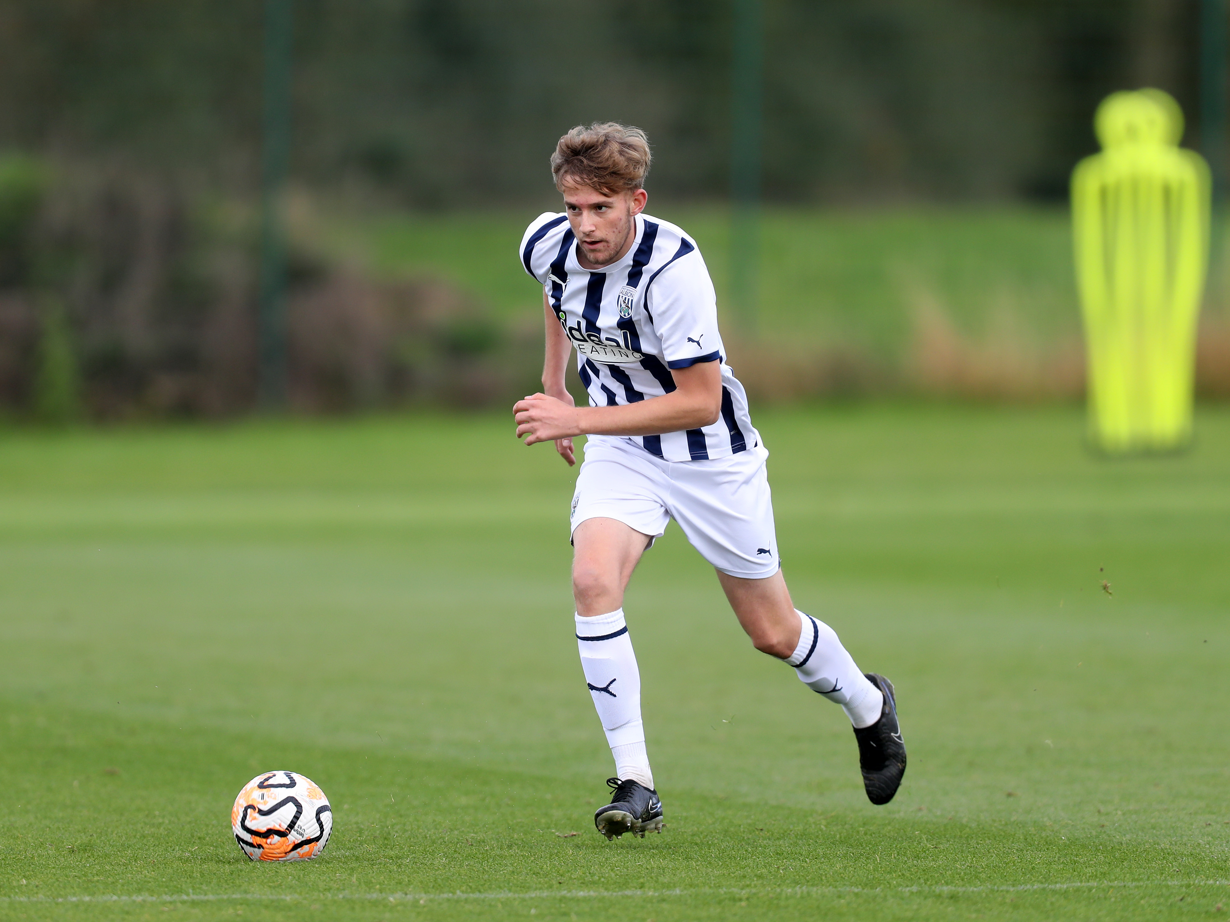 A photo of Albion U18s defender Rhys Morrish, in the 23/24 home kit, in action at the club's Walsall training ground