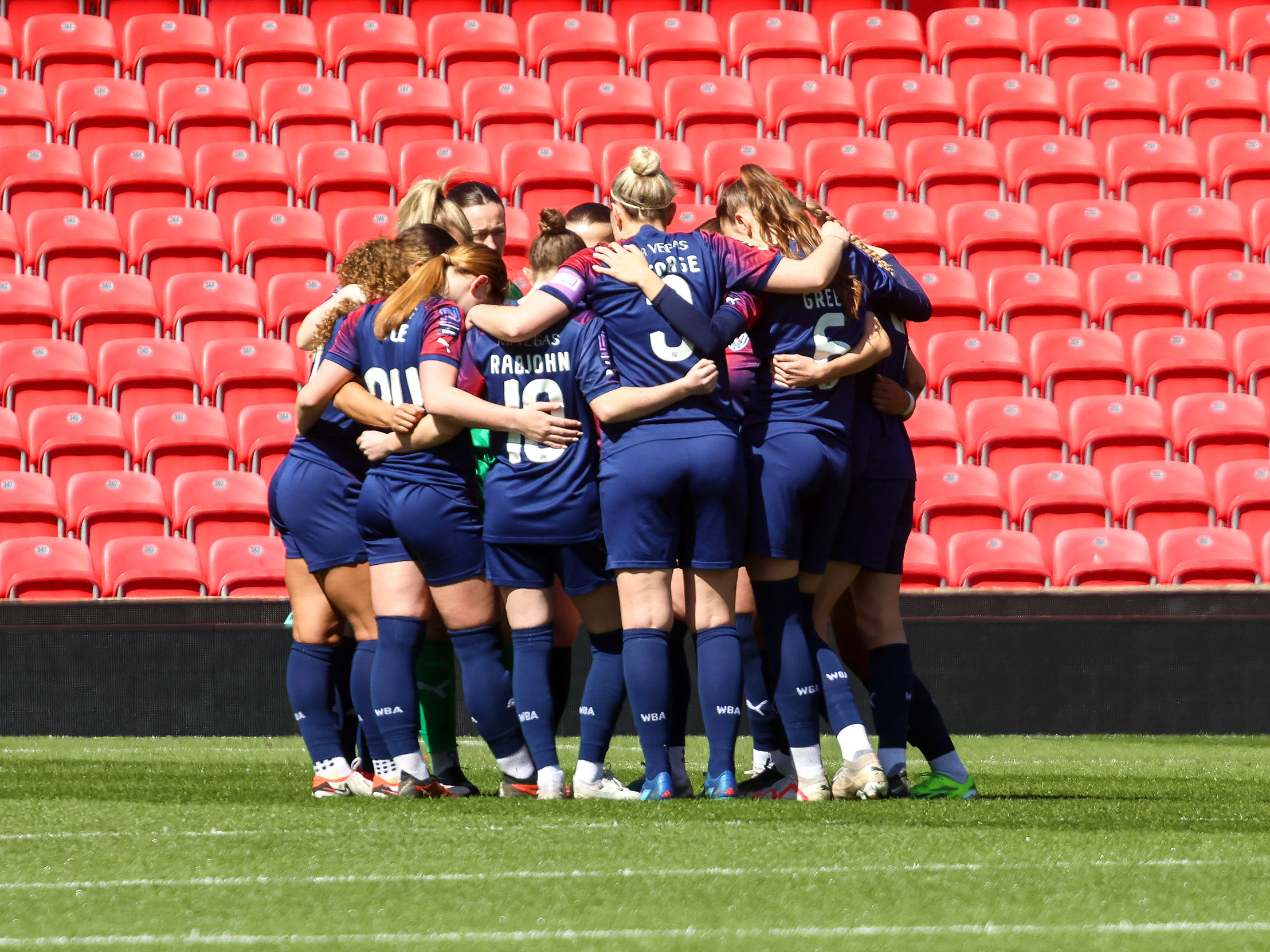 An image of Albion Women in a huddle at Stoke's Bet365 Stadium