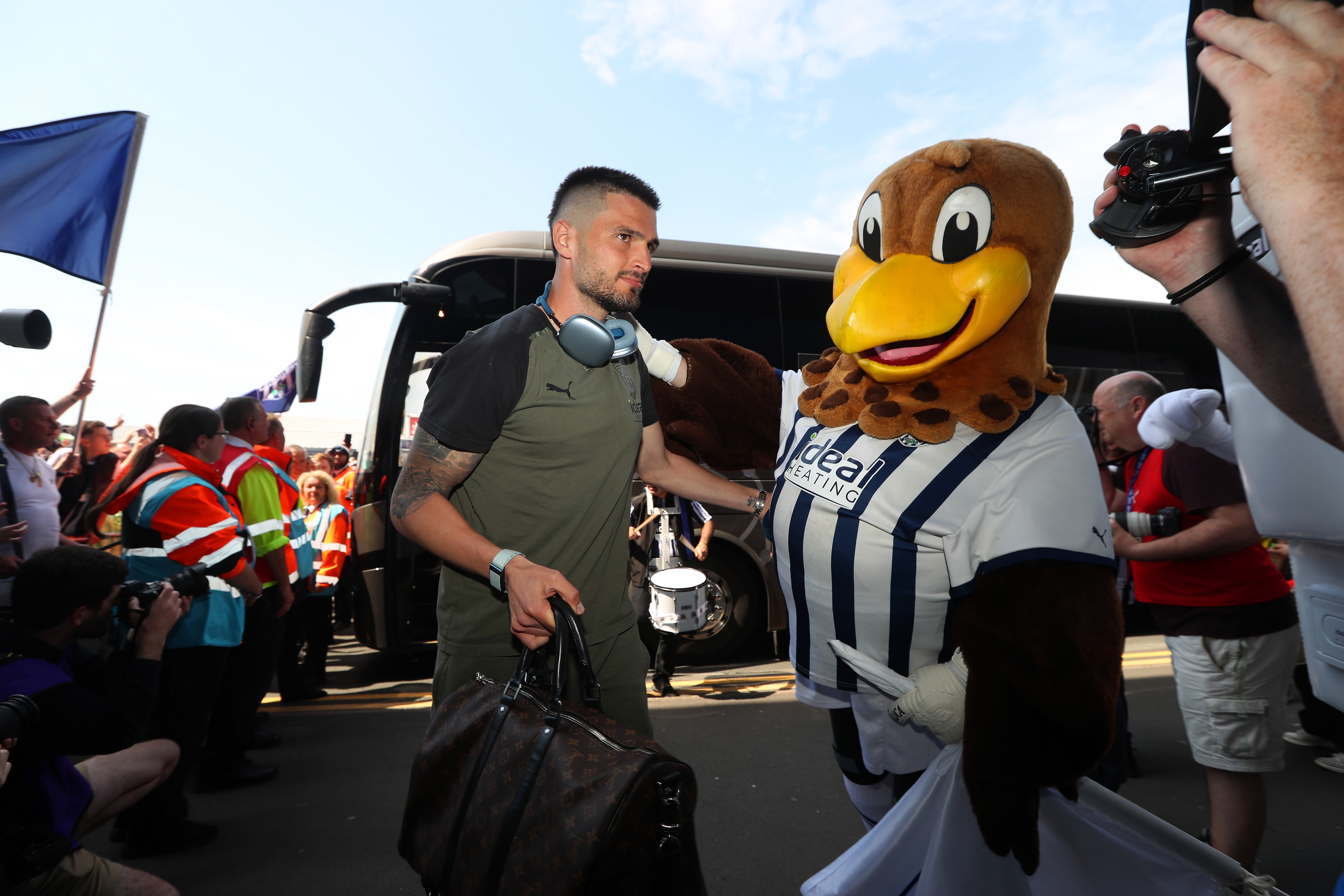 Okay Yokuslu is greeted by Baggie Bird upon arrival at The Hawthorns before Albion's game with Southampton 