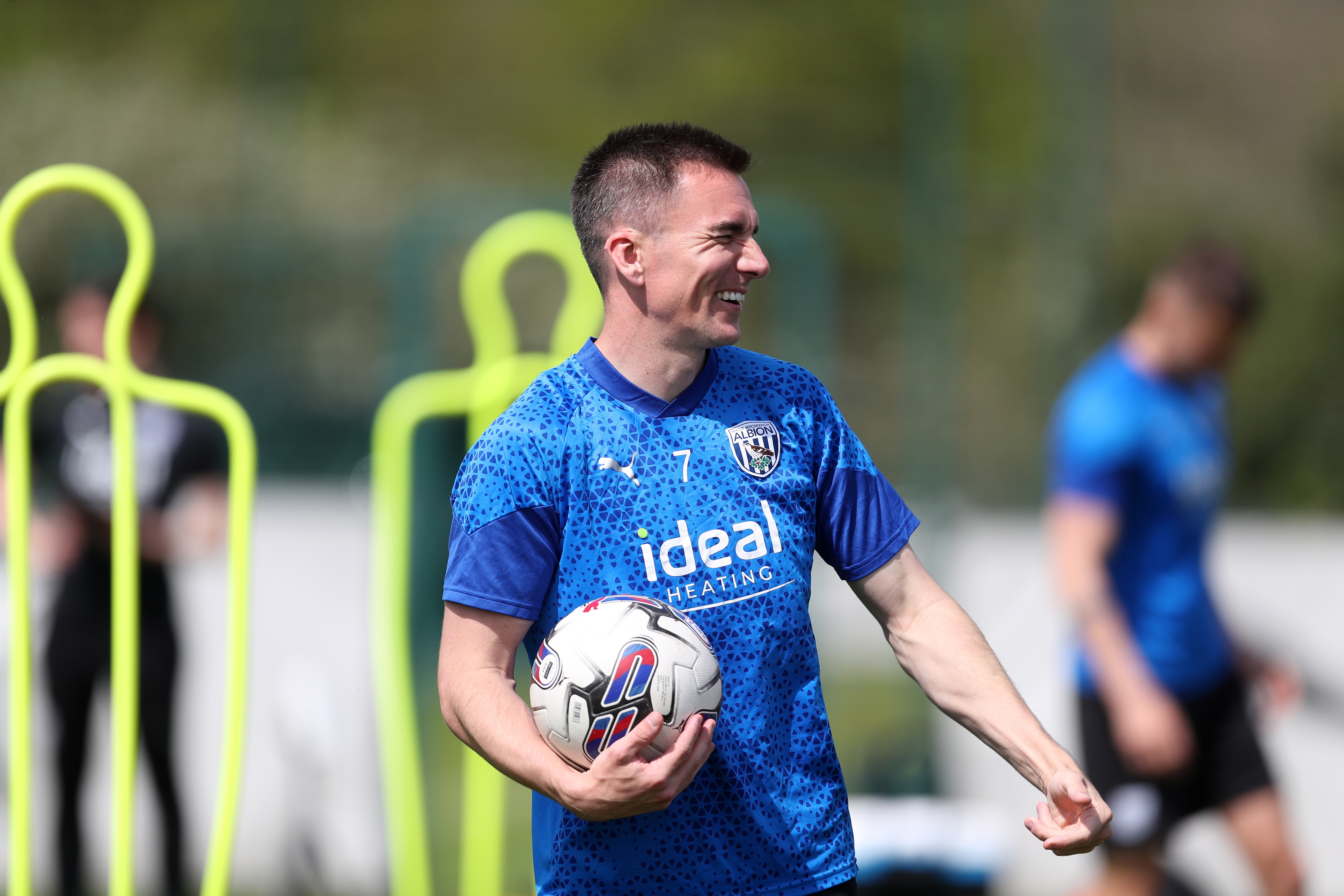 Jed Wallace smiling while holding a ball in training 