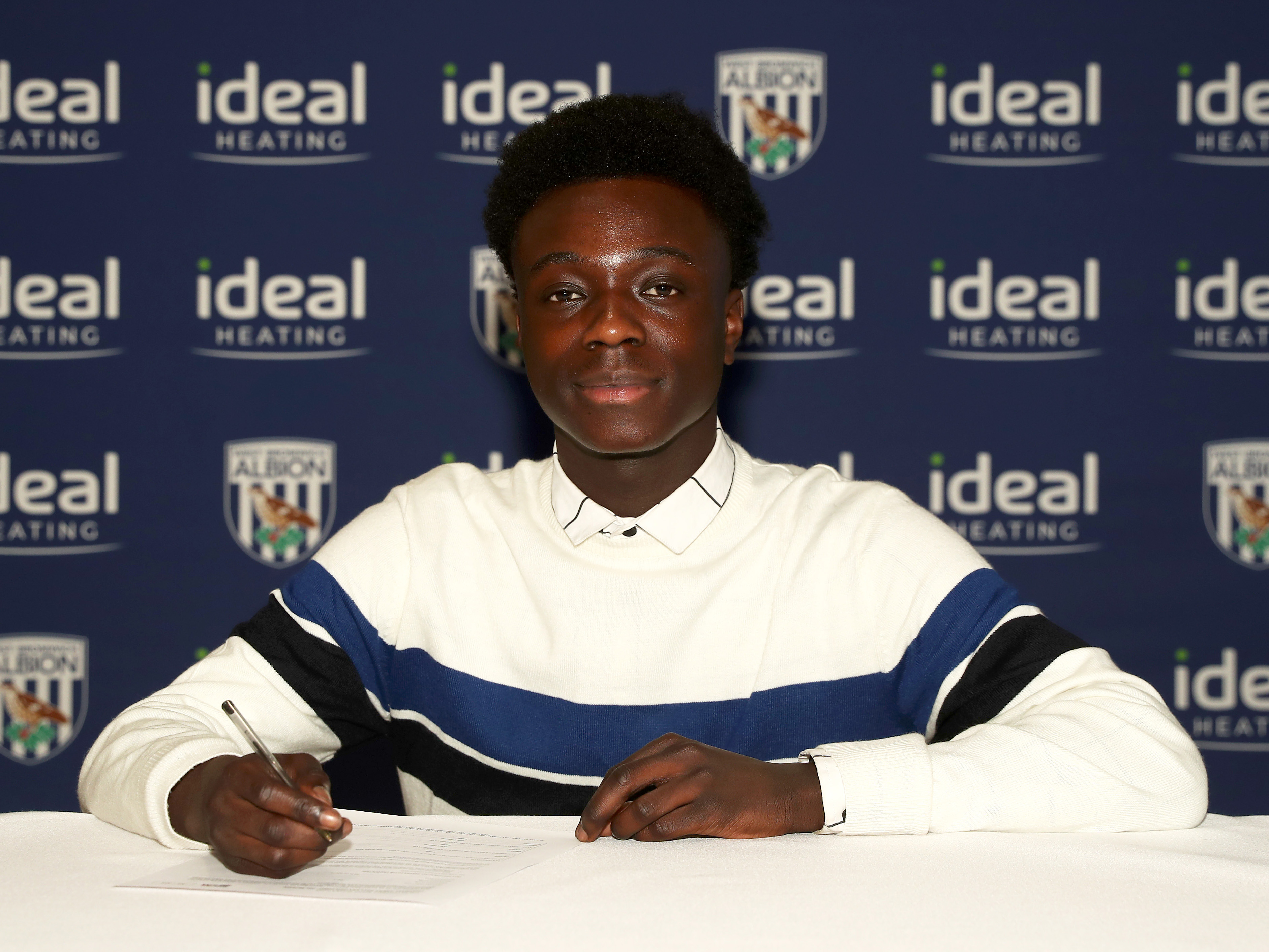 A photo of Idrissa Dauda signing his scholarship deal