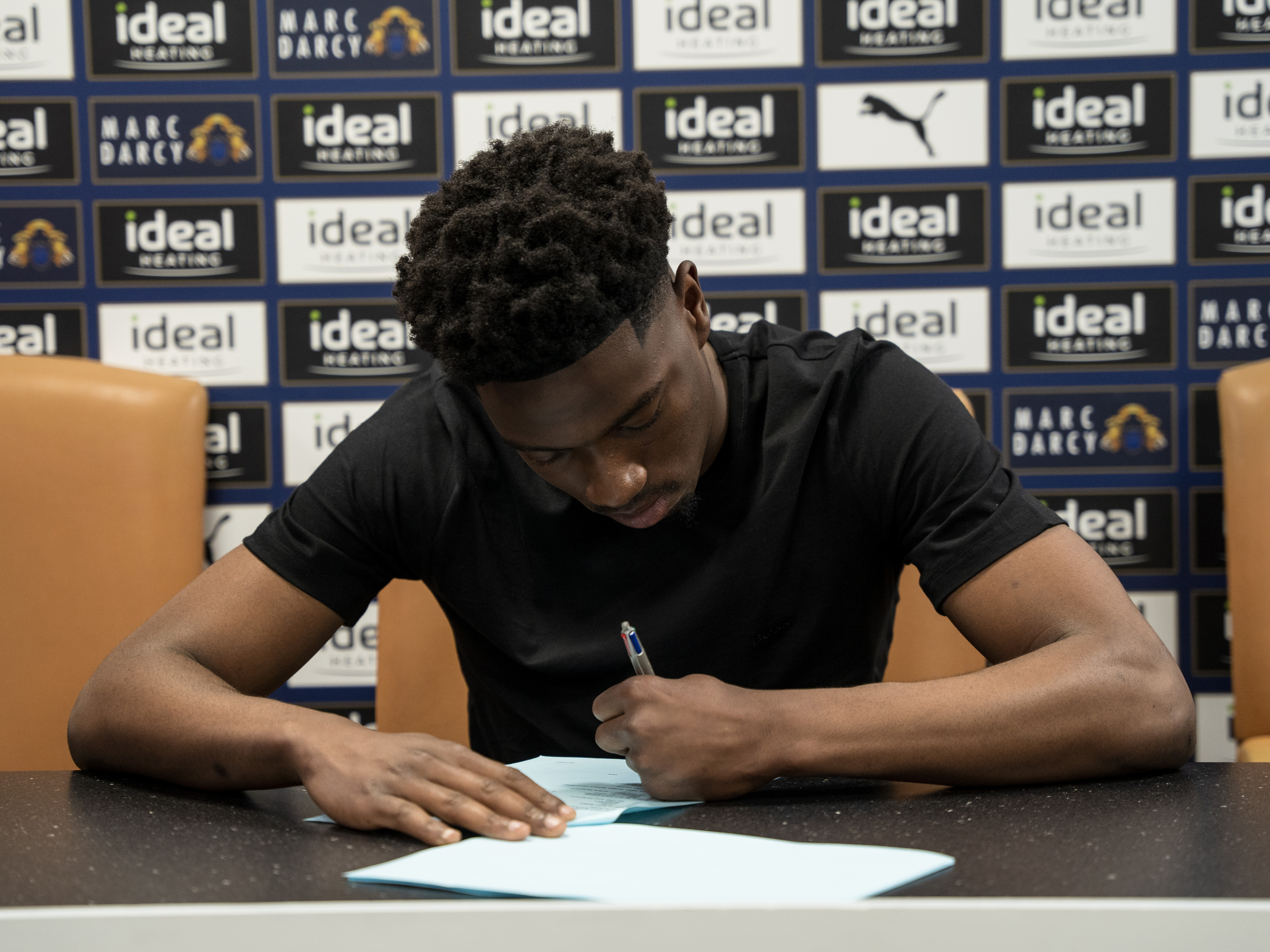 A photo of young Albion goalkeeper Ben Cisse signing his professional contract