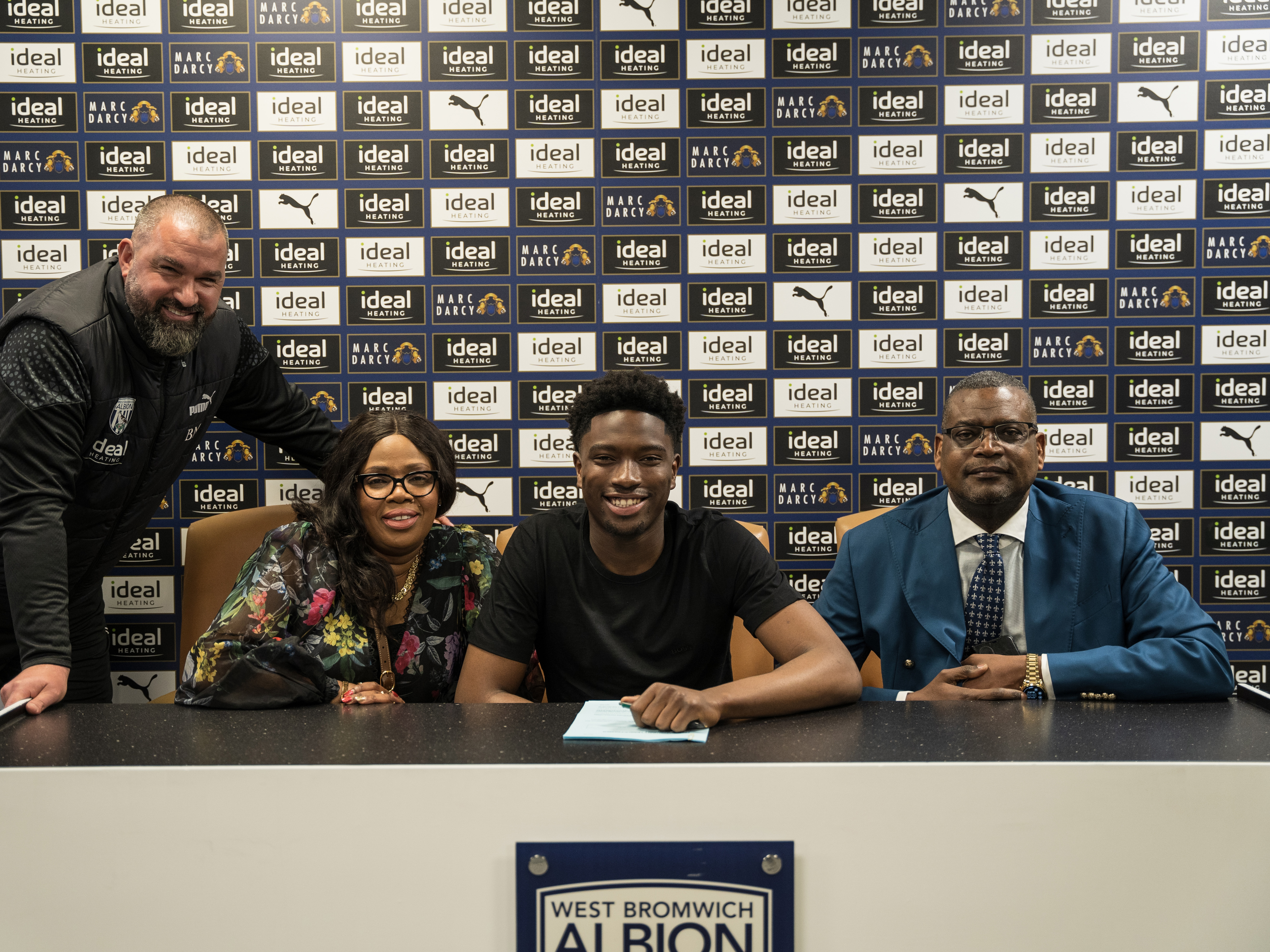 A photo of Ben Cisse, his family, and academy goalkeeping coach Boaz Myhill posing for Cisse signing his professional contract