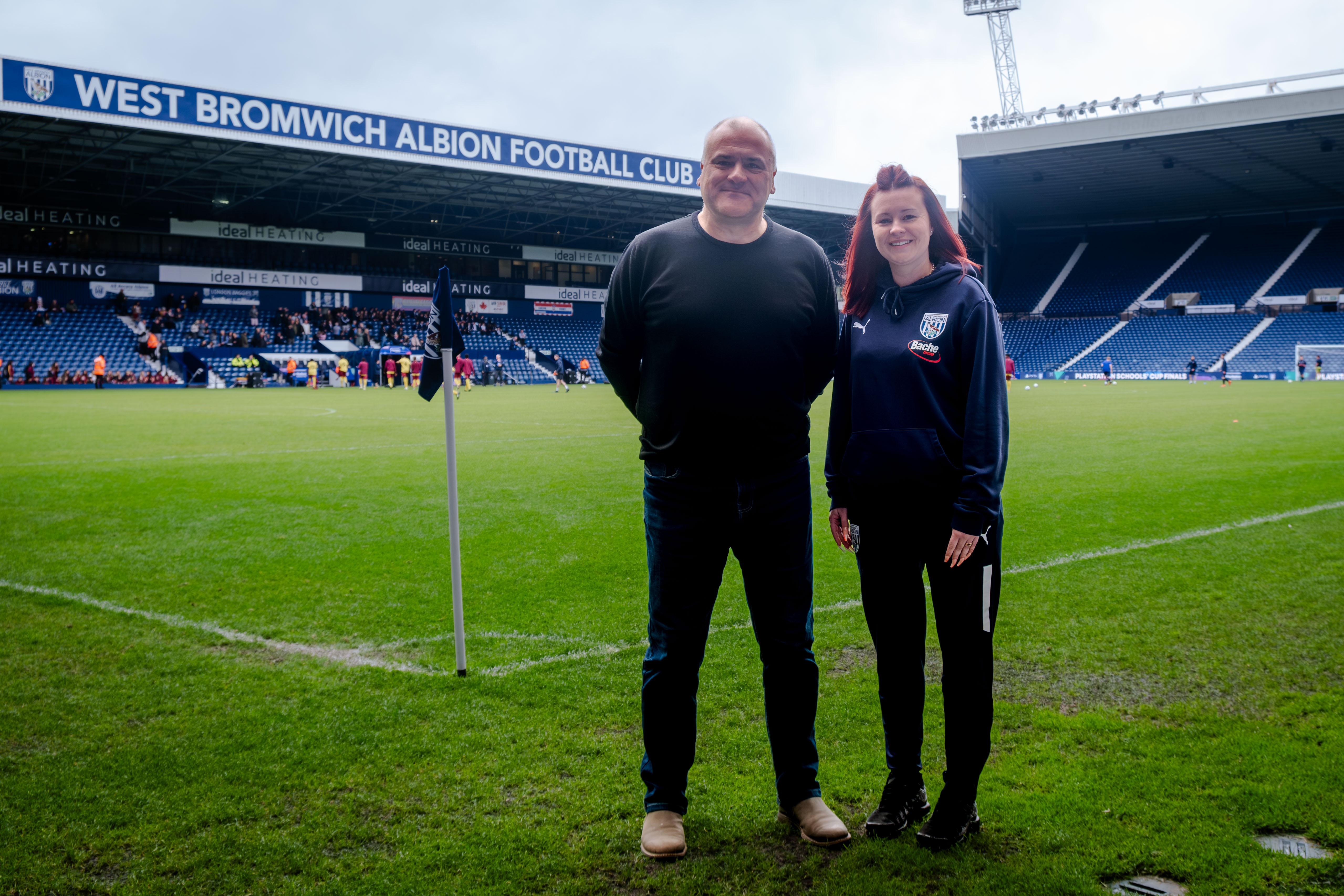 Bennett Whitehouse CEO Gavin Whitehouse and Events Coordinator Jayne Norton, pitch side with West stand in the background.