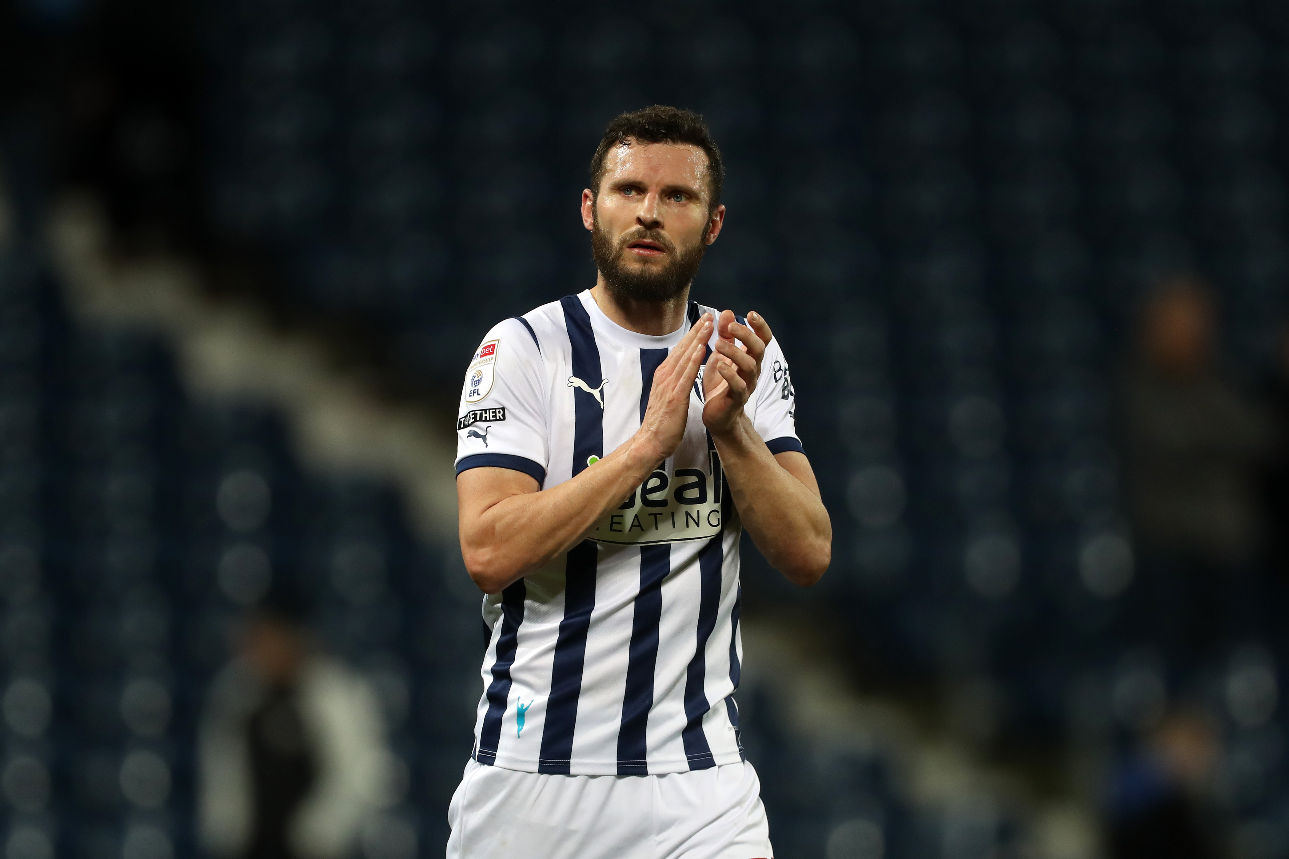 Erik Pieters applauding Albion fans while wearing the home kit 