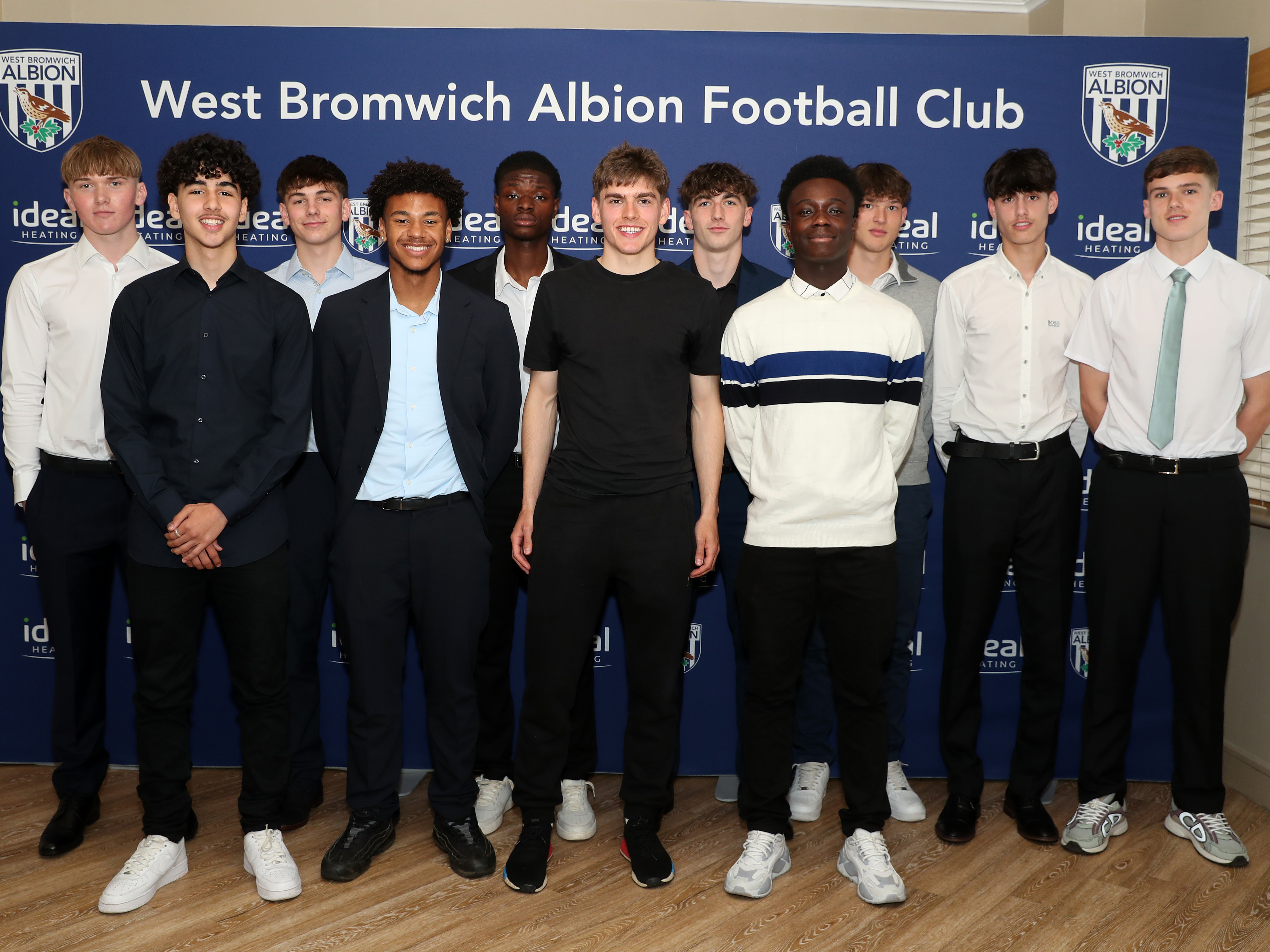 A photo of Albion's new scholars for the 2024/25 season, around academy graduate and first-team player Tom Fellows in centre of shot after signing their scholarships