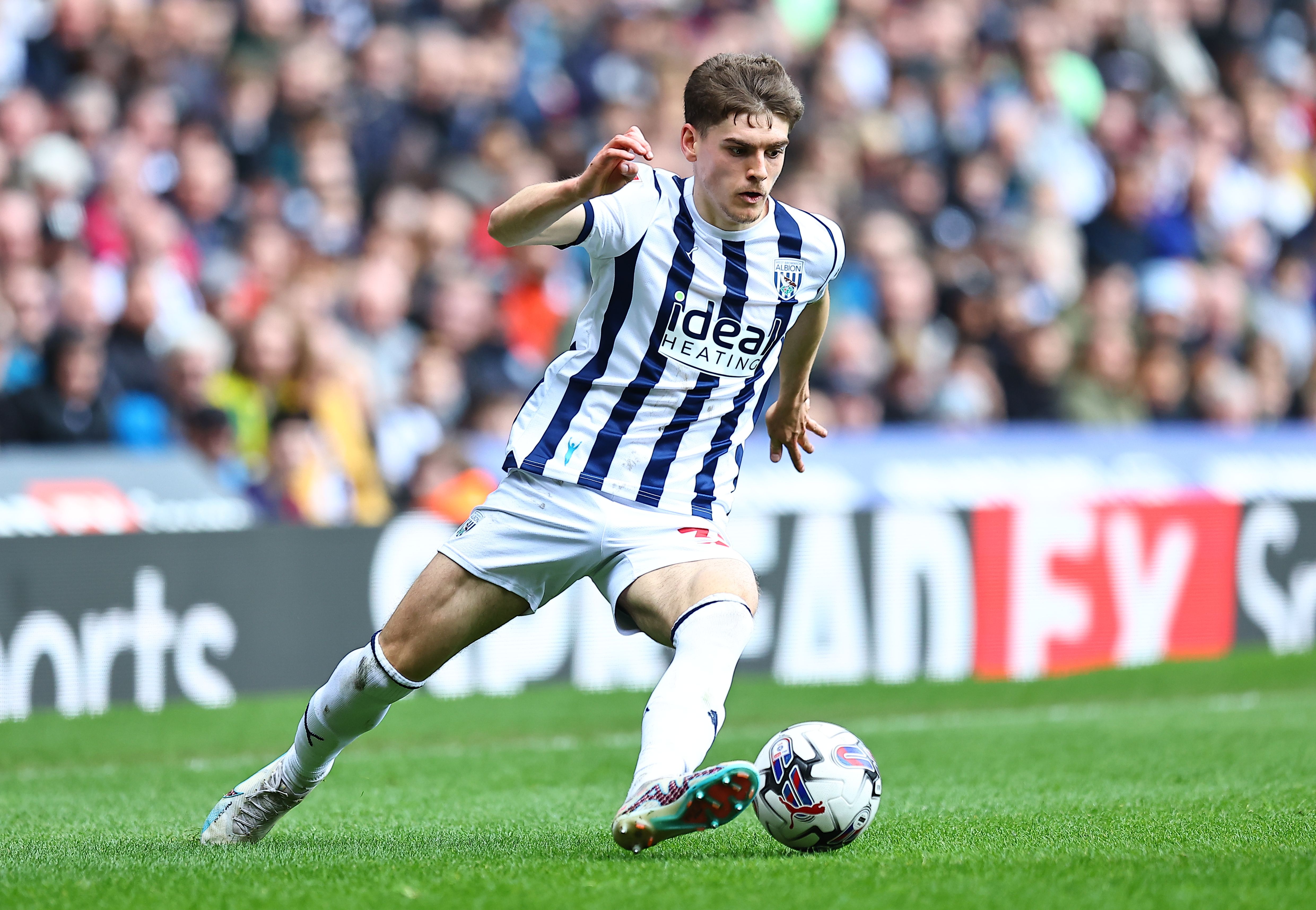 Tom Fellows running with the ball for Albion wearing the home kit 
