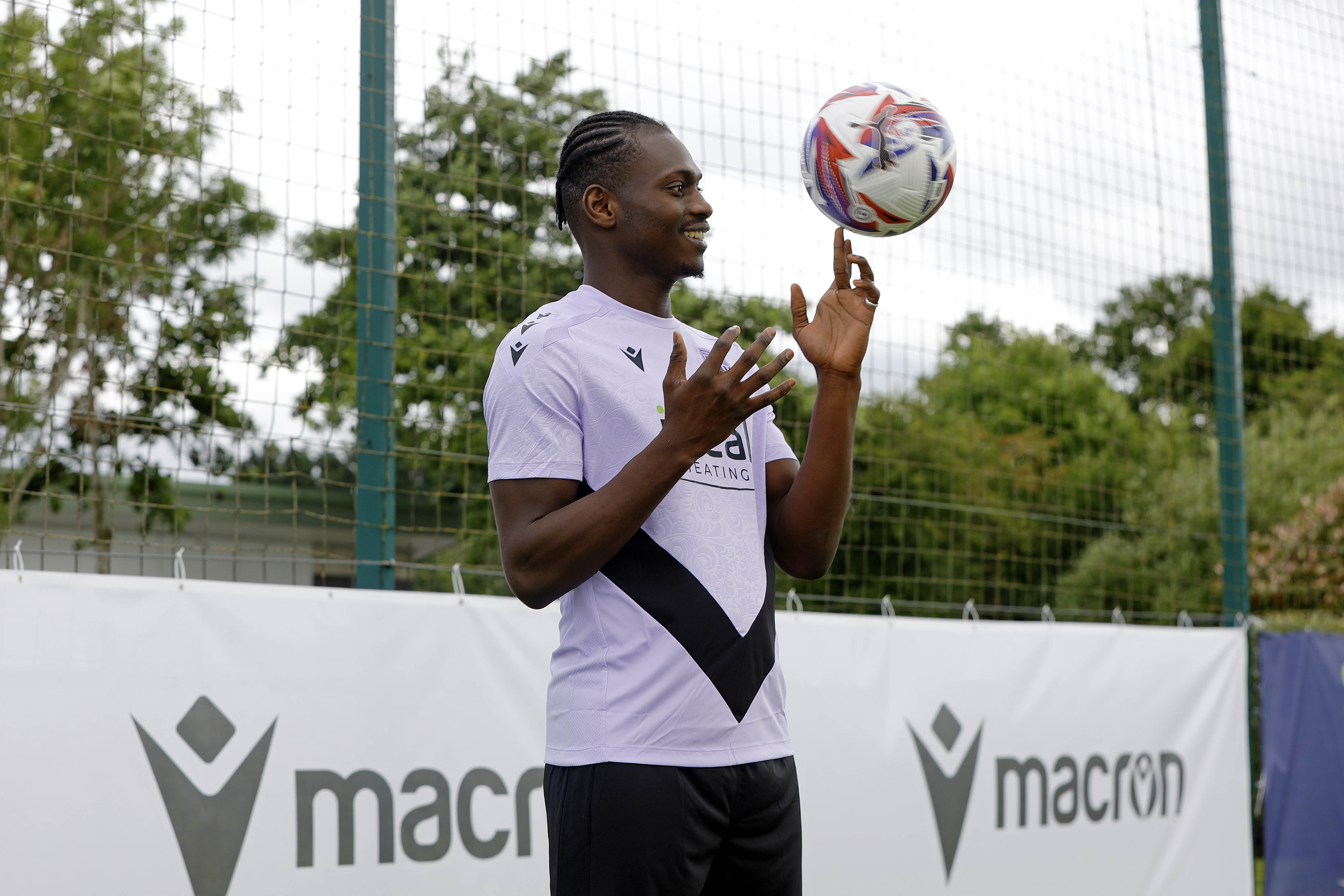 Ousmane Diakité smiling while juggling a football