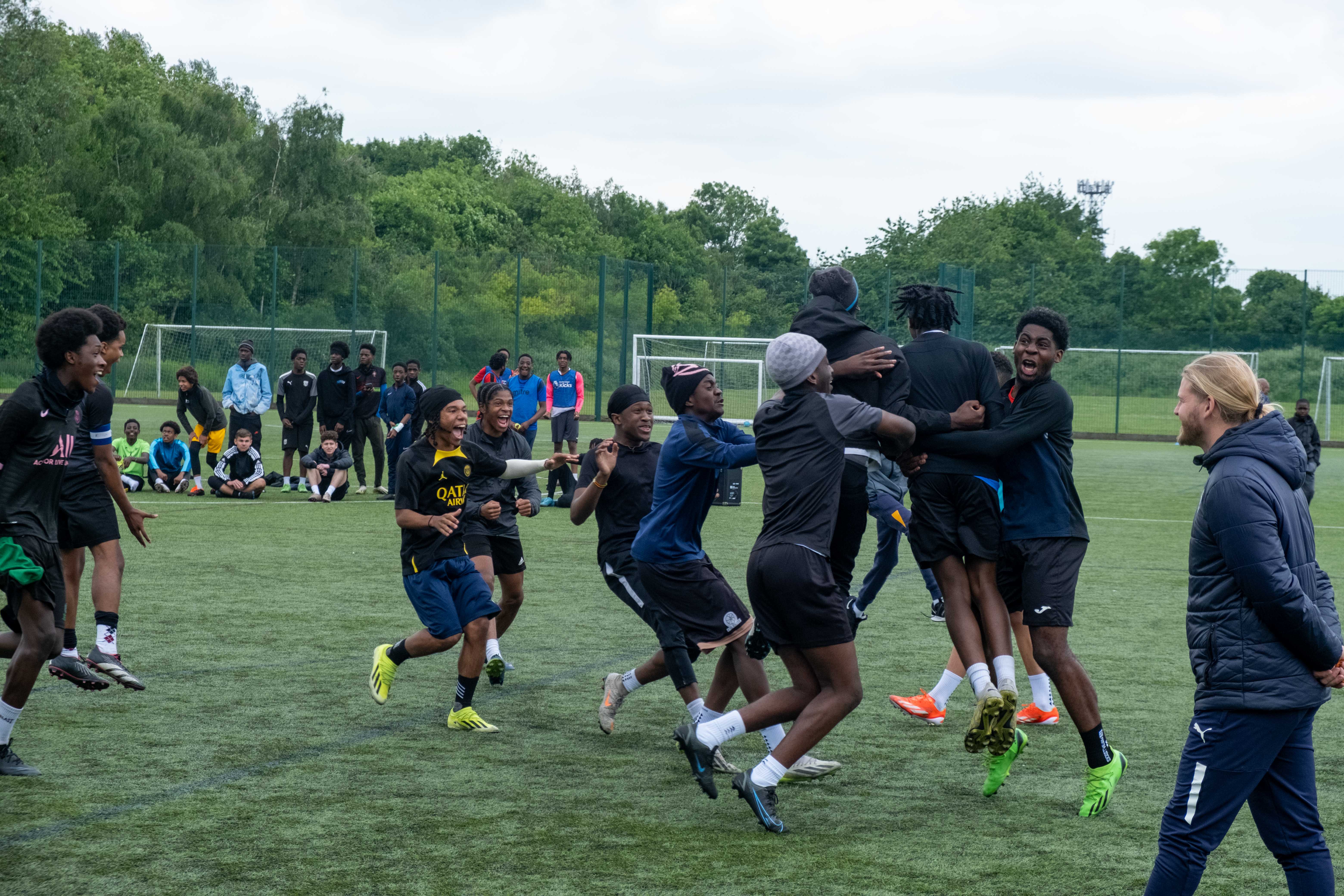 Team (Non bibs) jumping for joy, celebrating a penalty shoot out win.