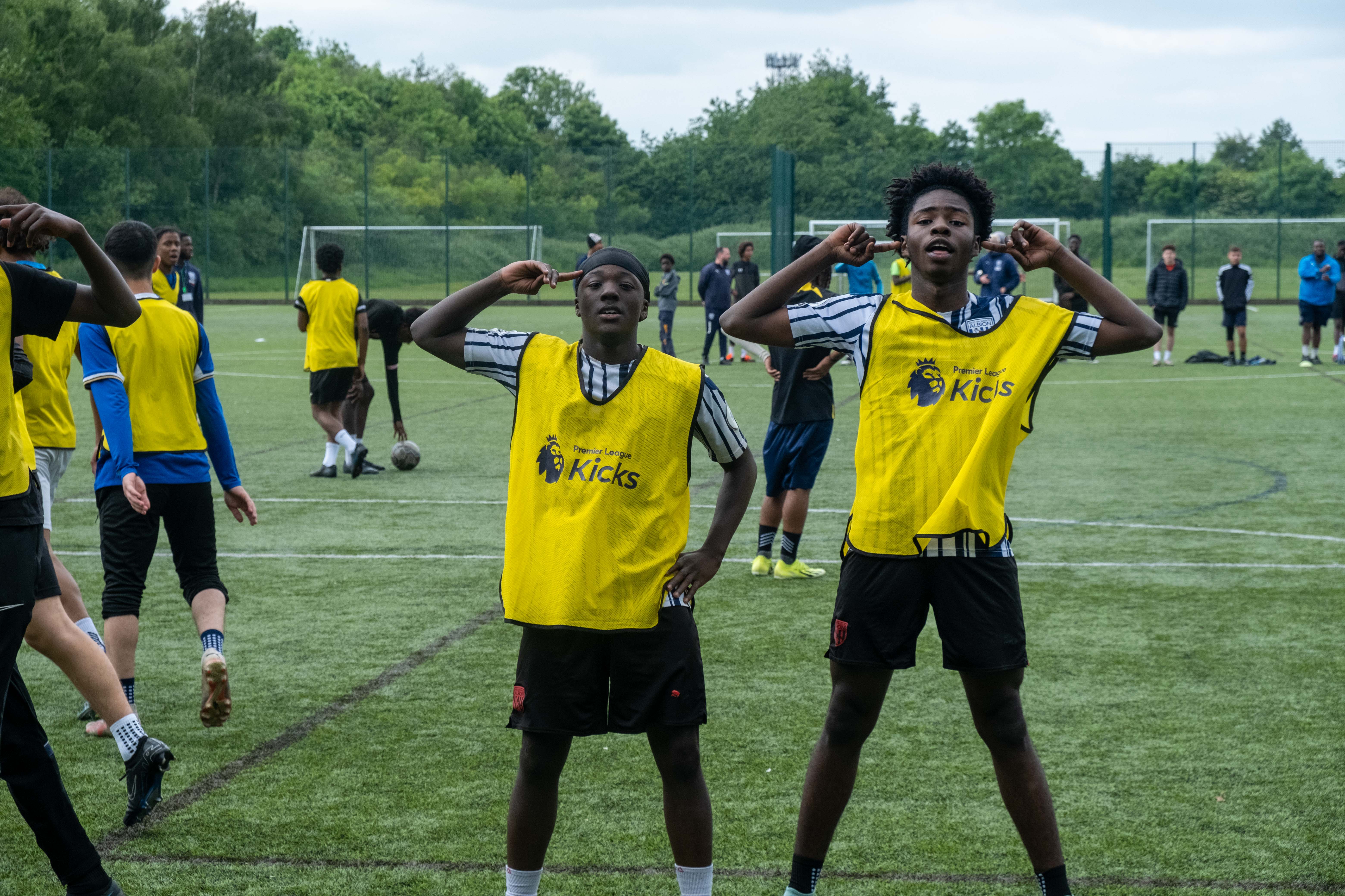 Two yellow bib players, doing the "Rashford" celly.