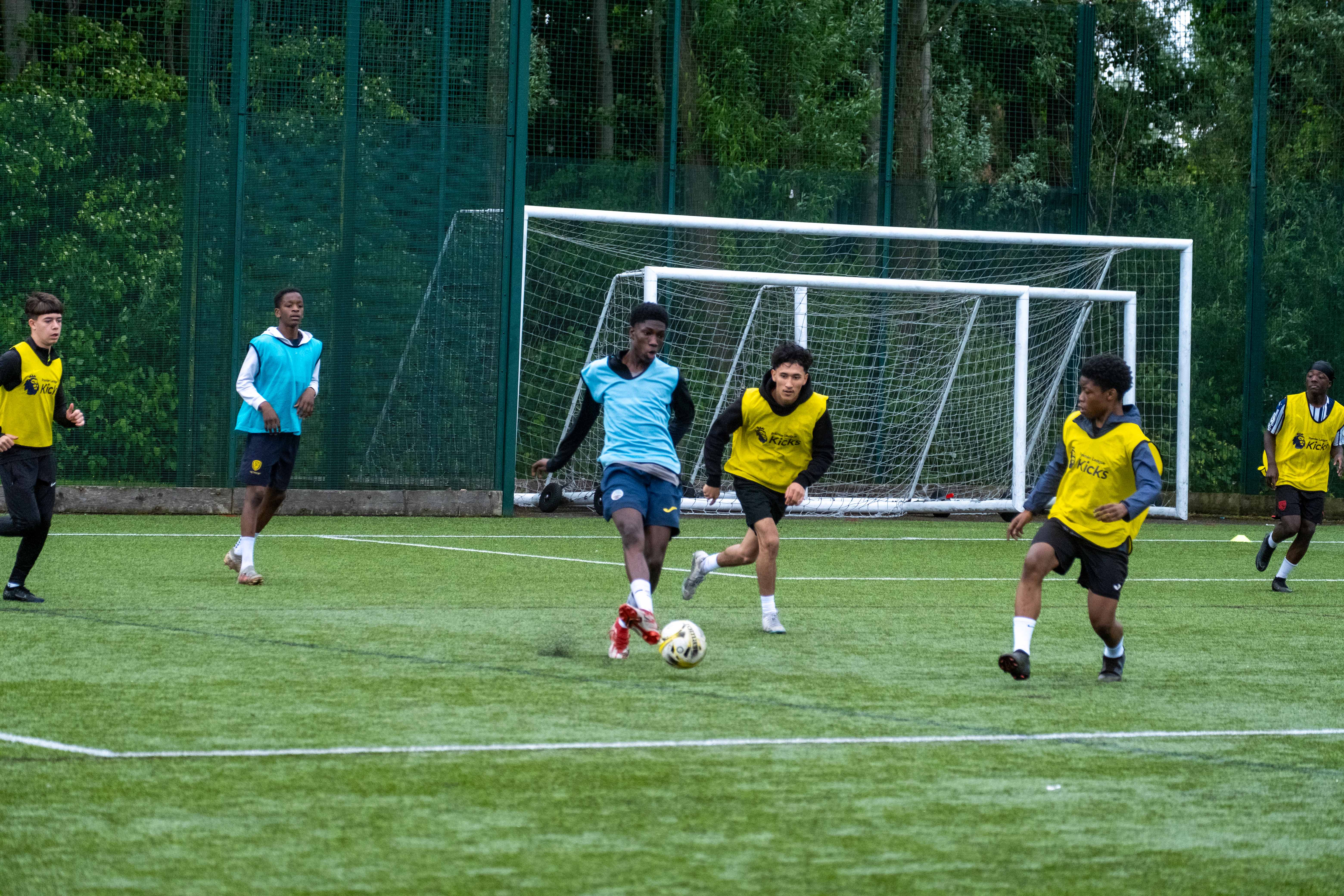 Aqua blue team in possession of the ball, yellow bibs chasing.