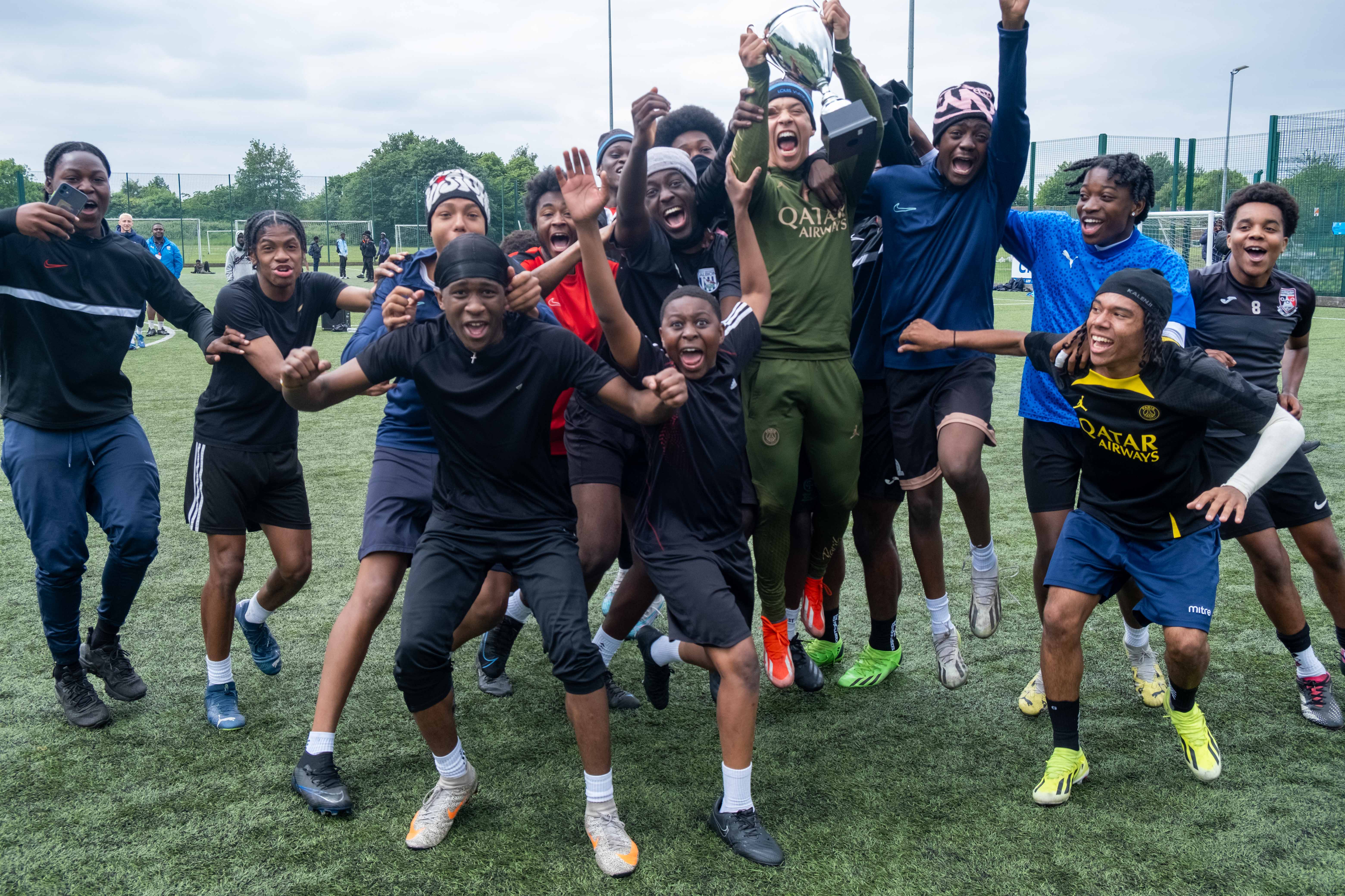 Winning team (Non bibs) jumping for joy with the winners trophy.