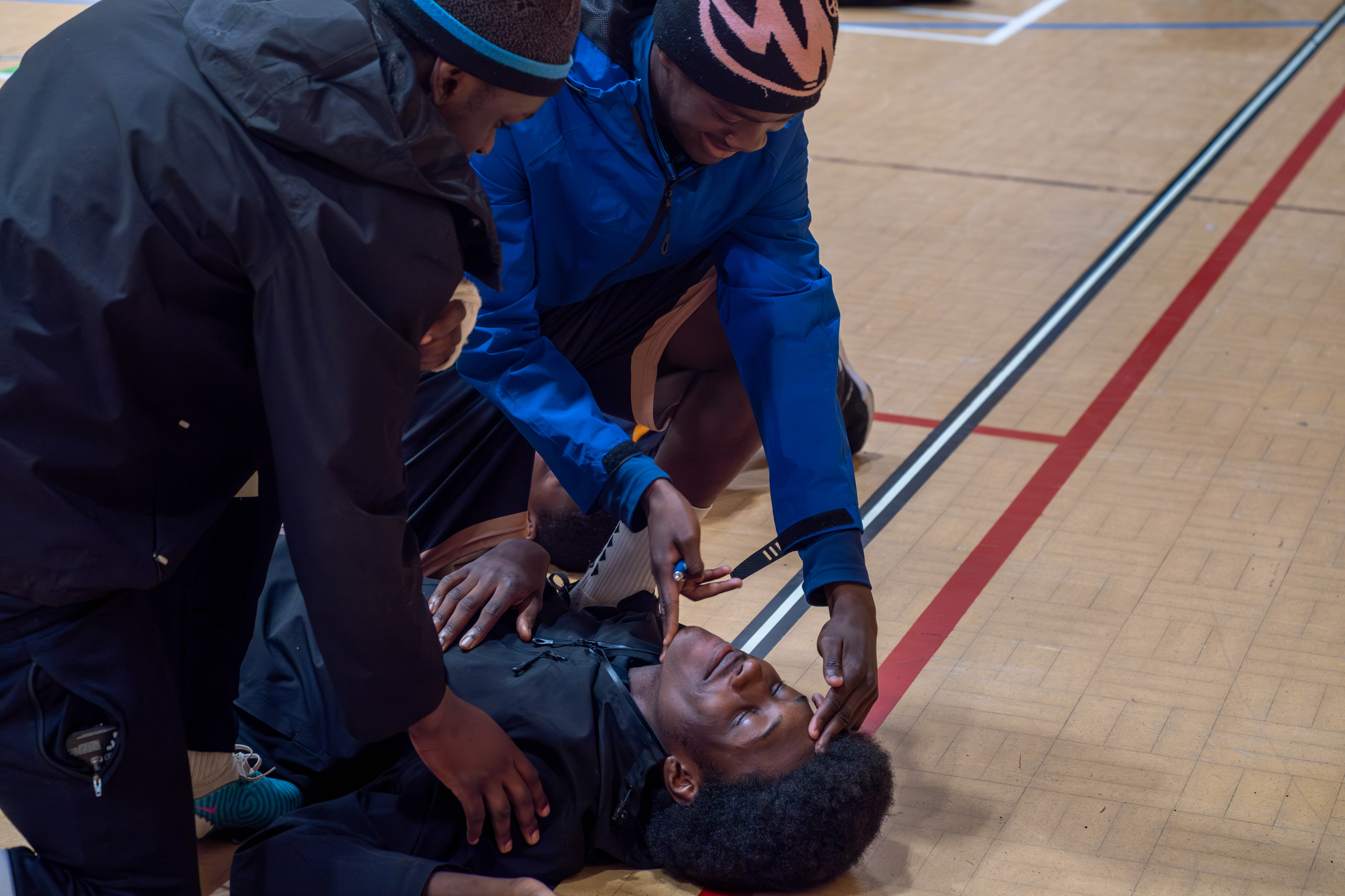 Two participants checking airway on another participant.