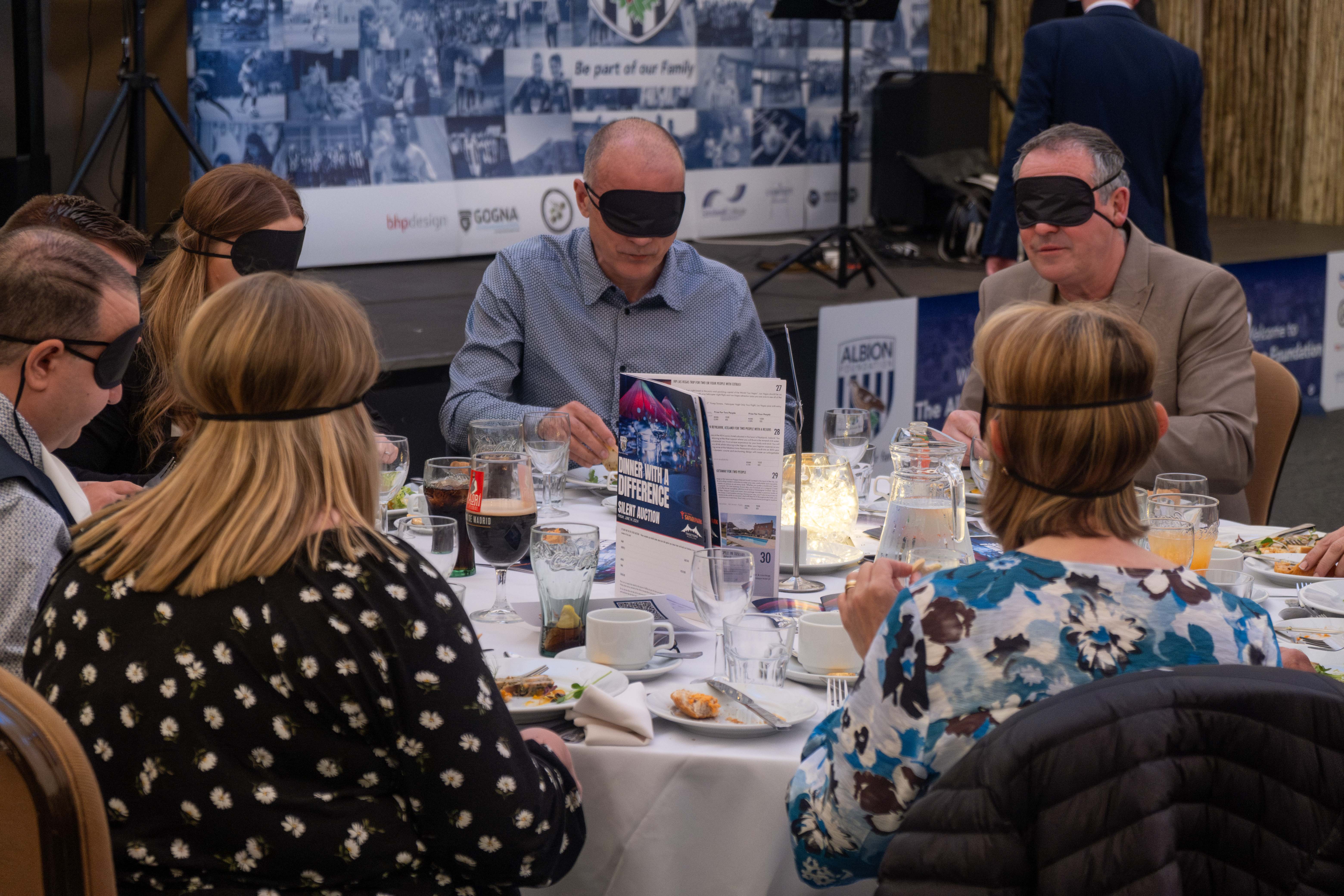 Diners seated at a table blindfolded.