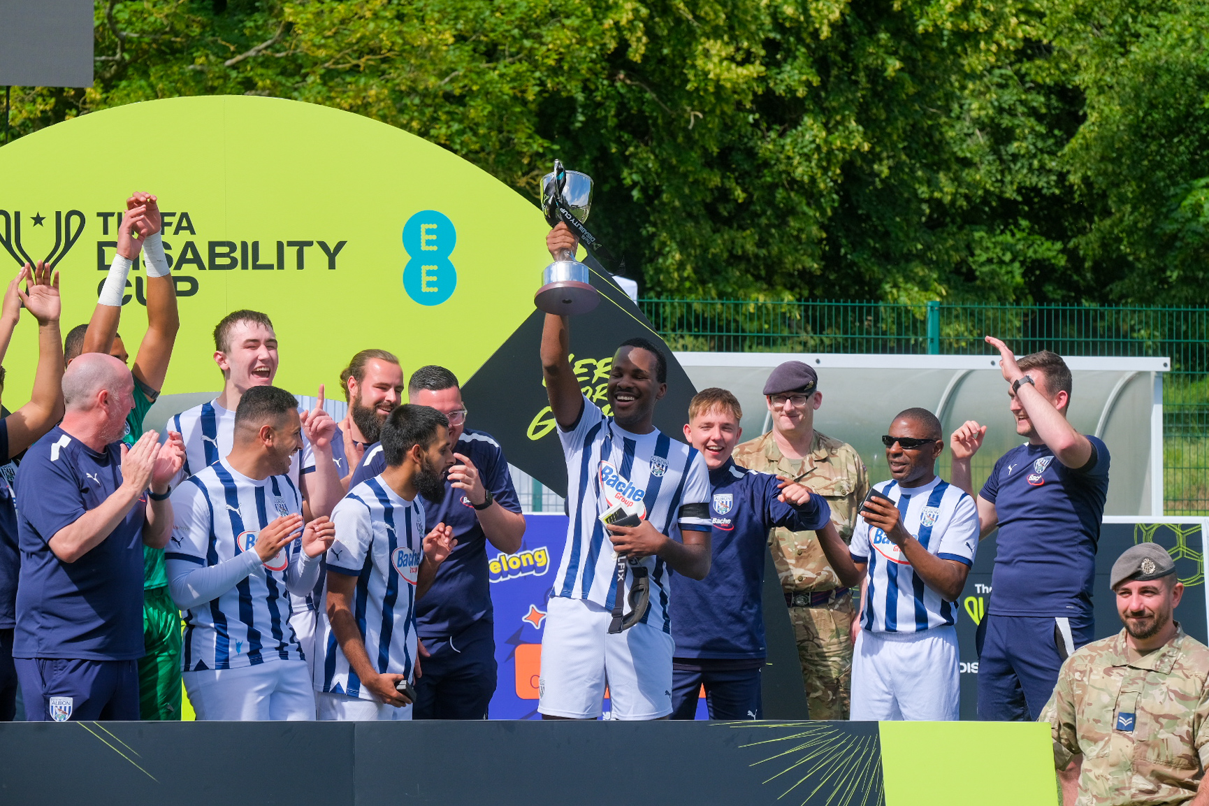 Paul Iyobo holding up the trophy with the rest of WBA Blind celebrating.