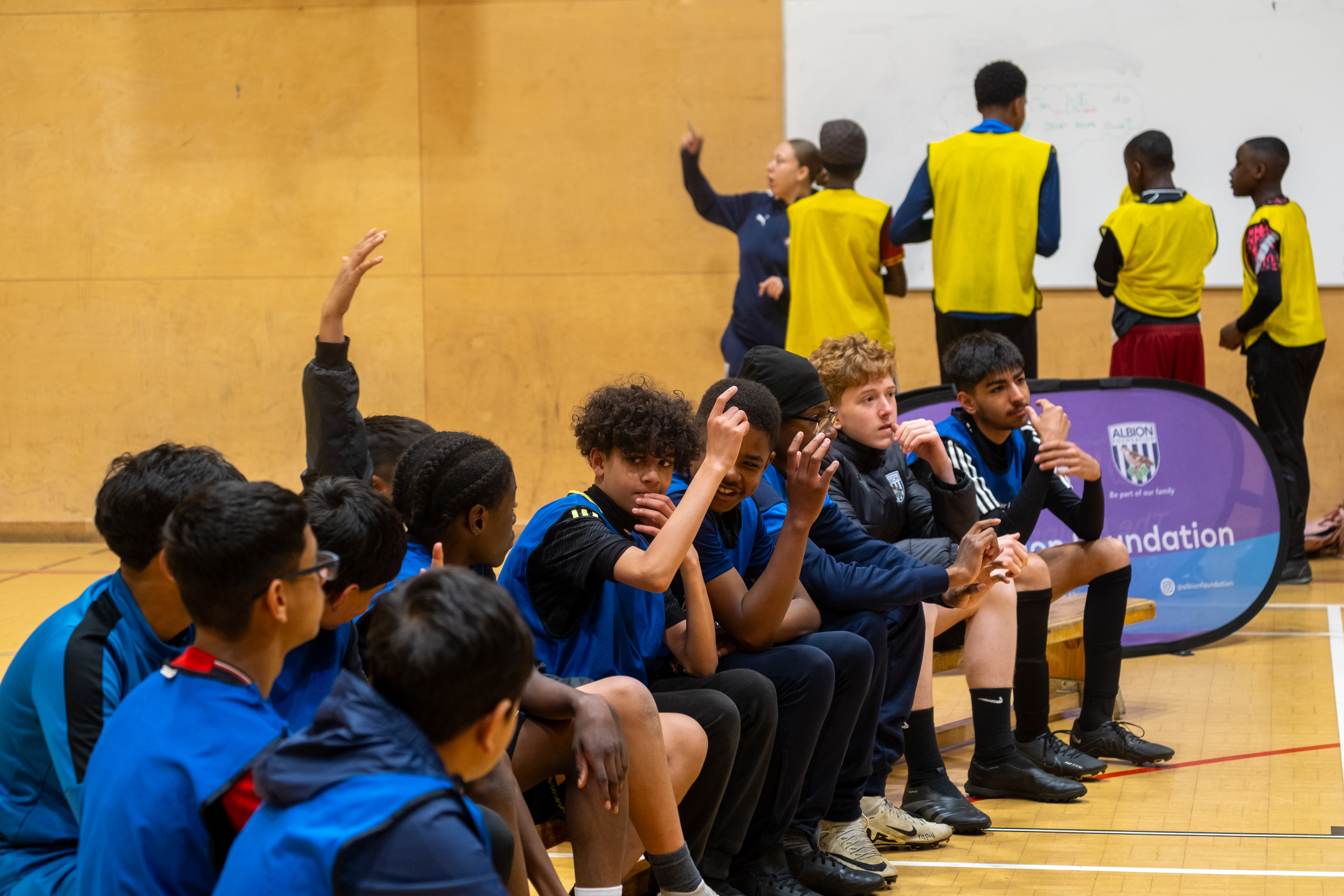 A group of Kicks camp participants raise their hands during their knife crime workshop.