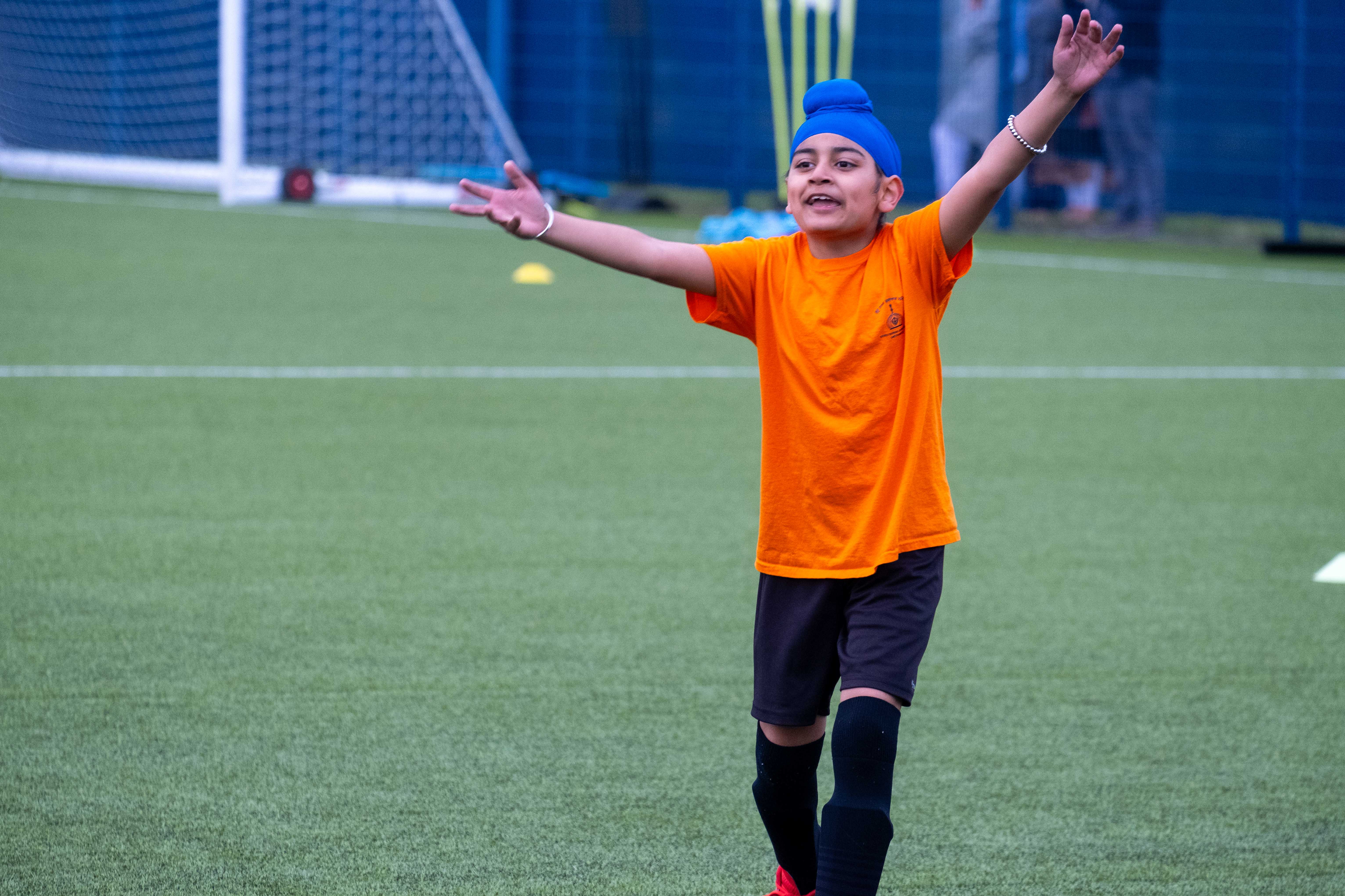 A participant wearing an orange shirt holds his arms aloft.