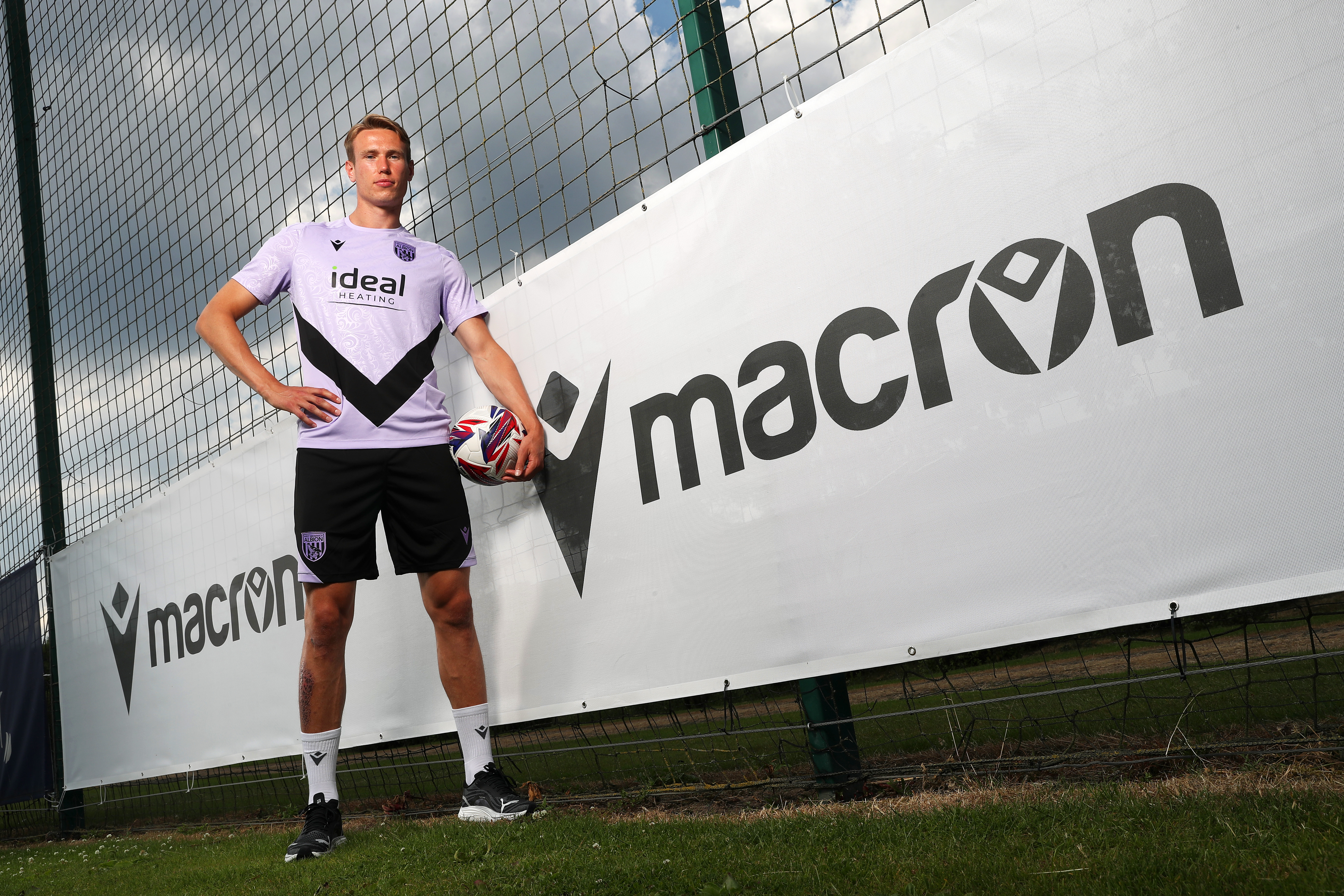 Torbjørn Heggem stood next to a Macron sign at the training ground 