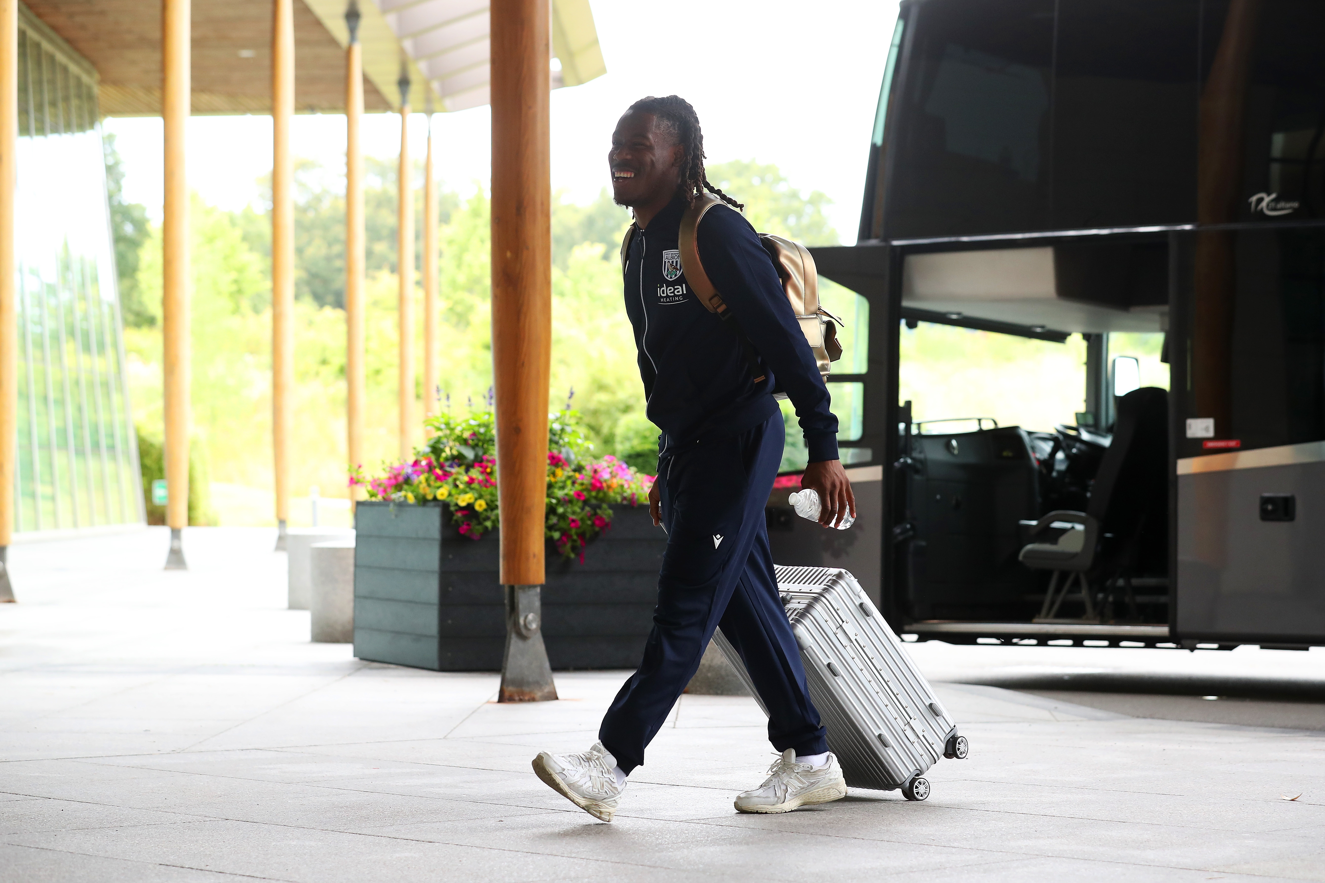 Brandon Thomas-Asante arriving at St. George's Park pushing a suitcase 