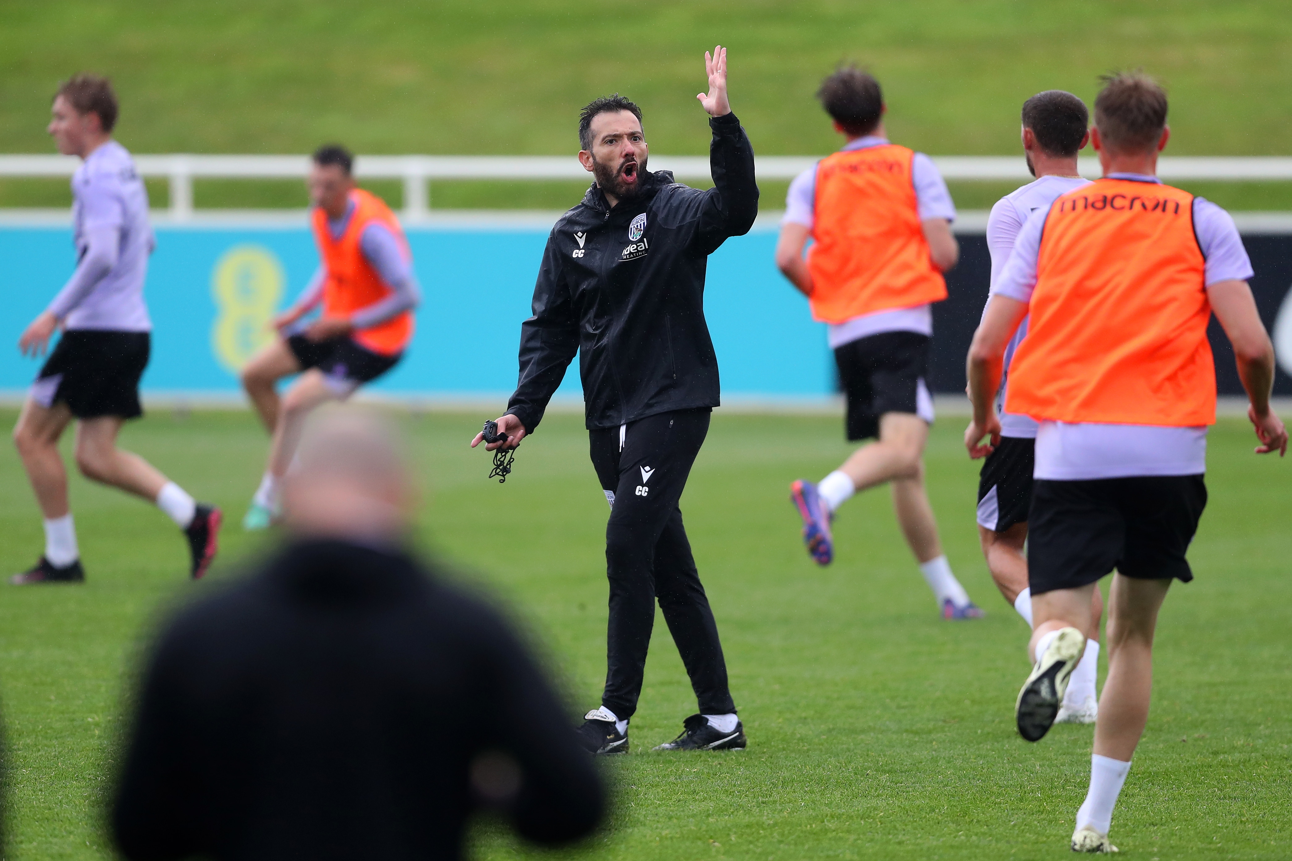 Carlos Corberán out on the training pitch at St. George's Park surrounded by players