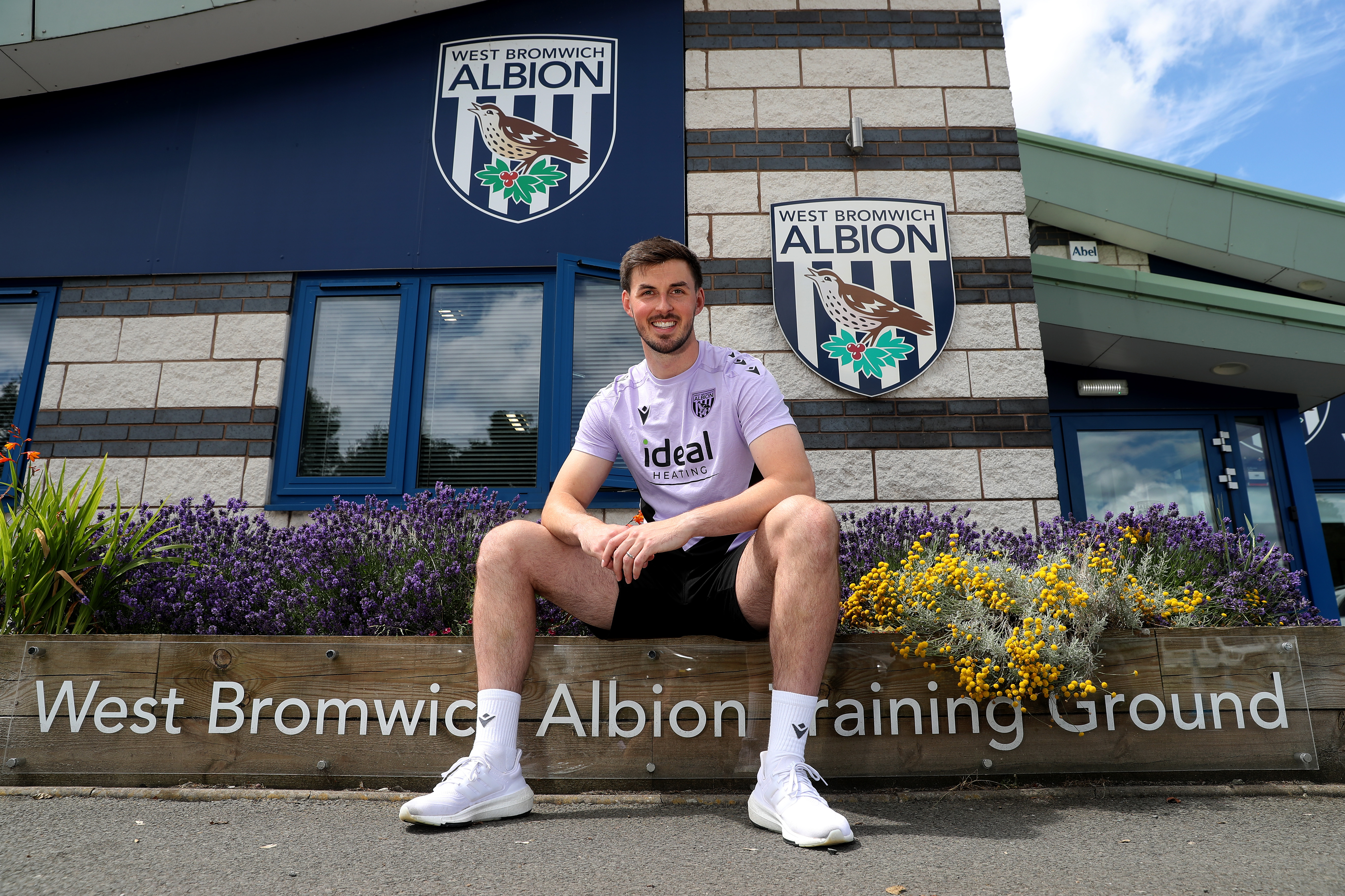 Joe Wildsmith sat outside the front of the training ground 