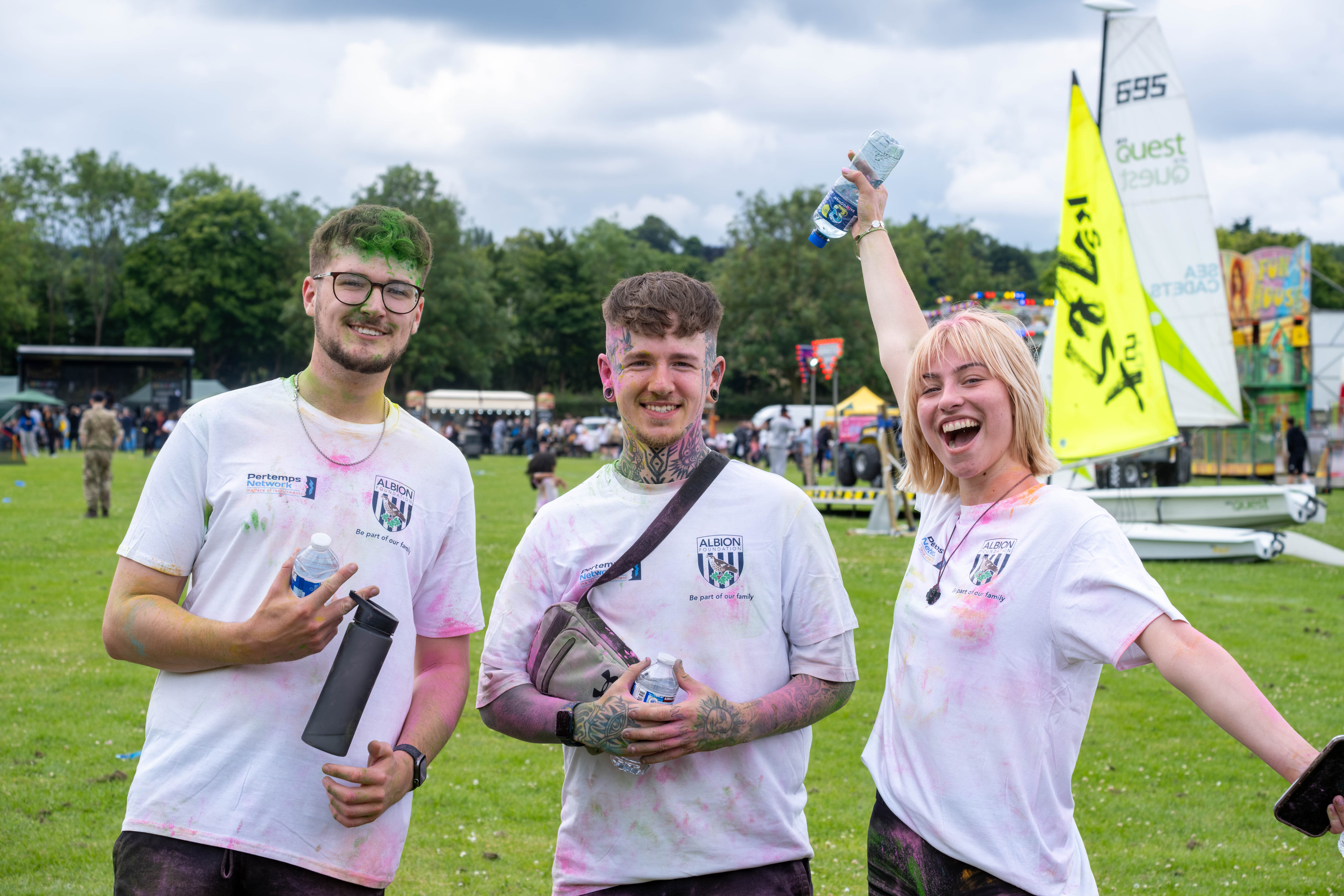 Three particpants posing for photo, girl on the right with arms spread out wide.