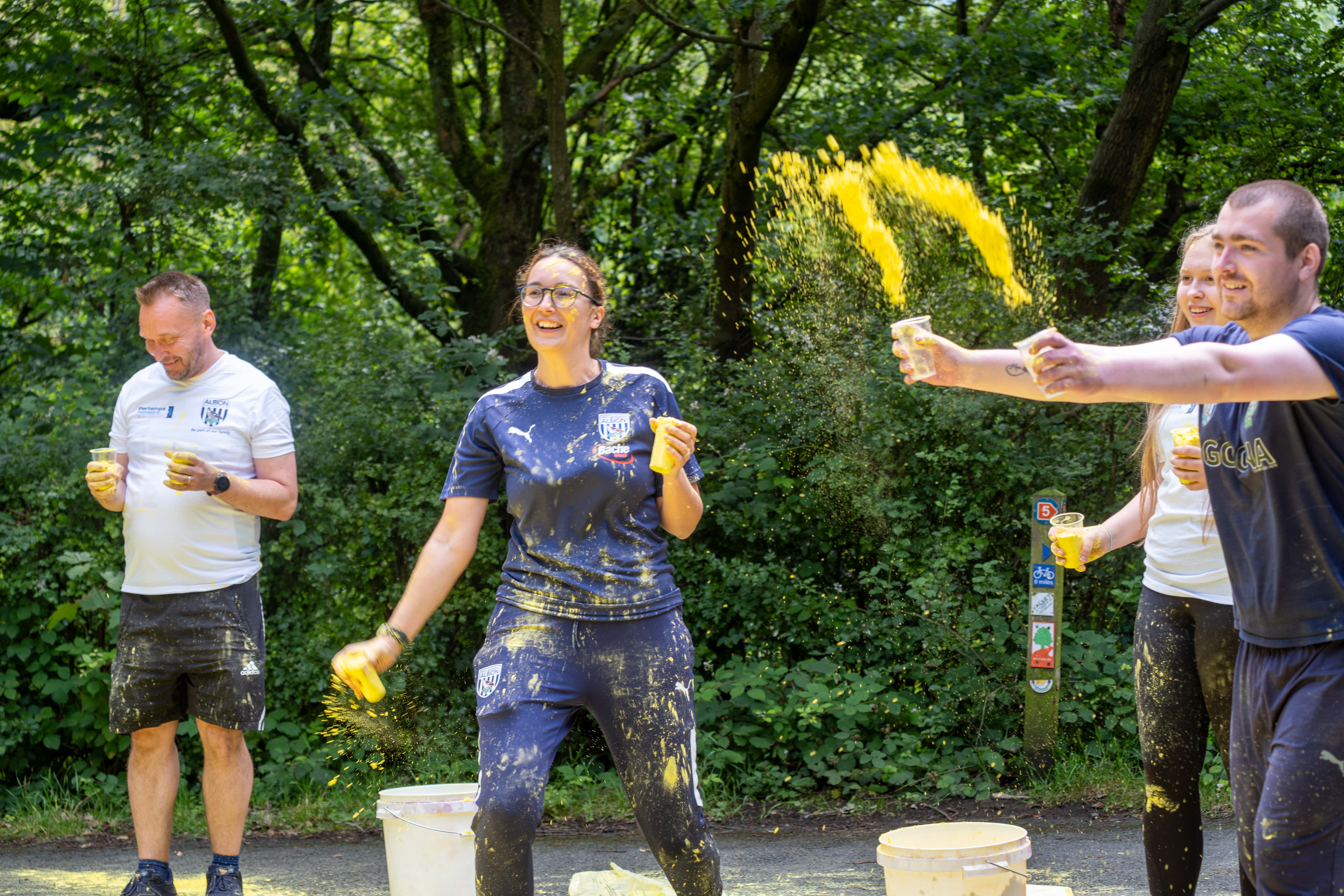 Foundation staff and volunteers at the colour station, throwing paint powder.