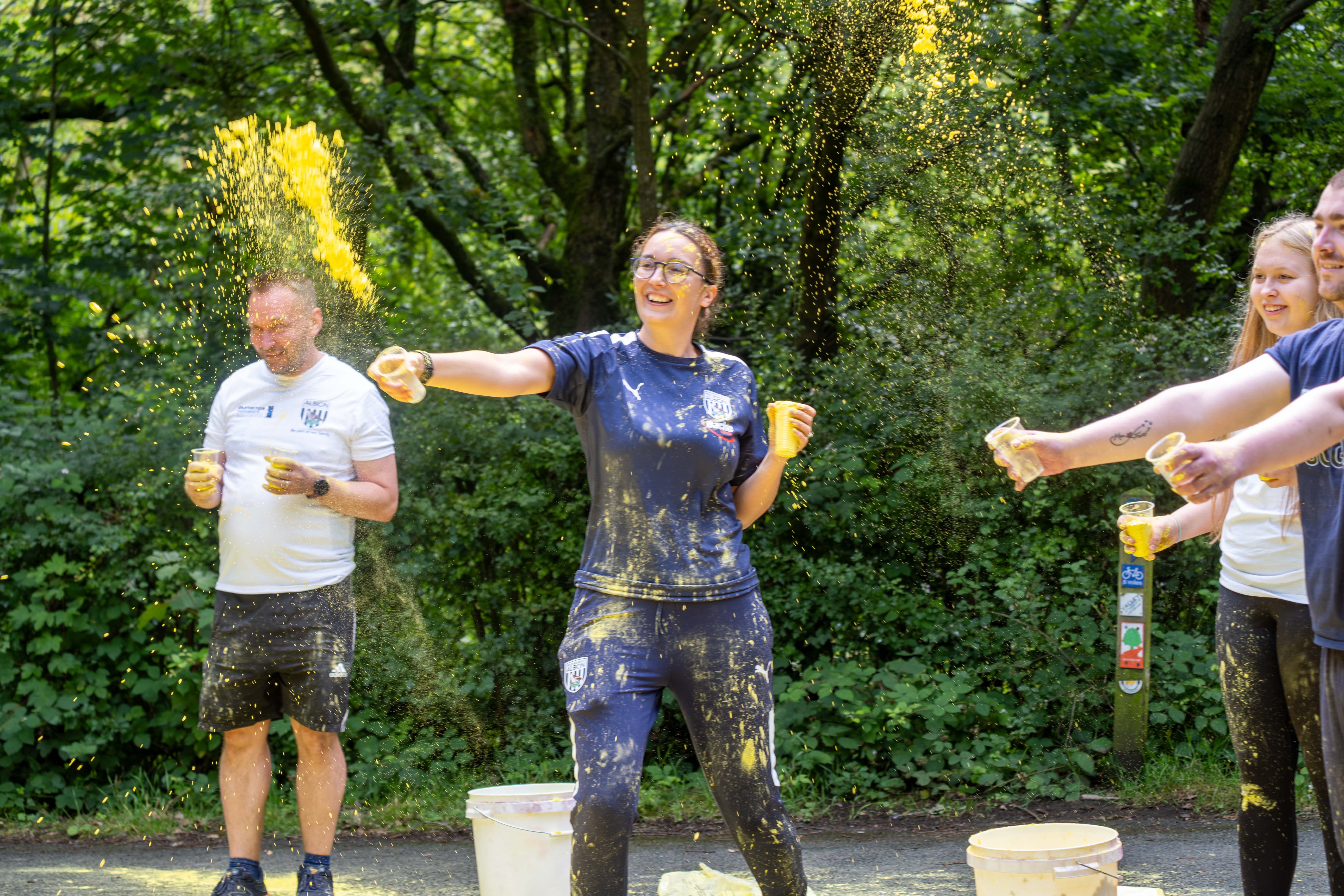 Foundation staff and volunteers at the colour station, throwing paint powder.