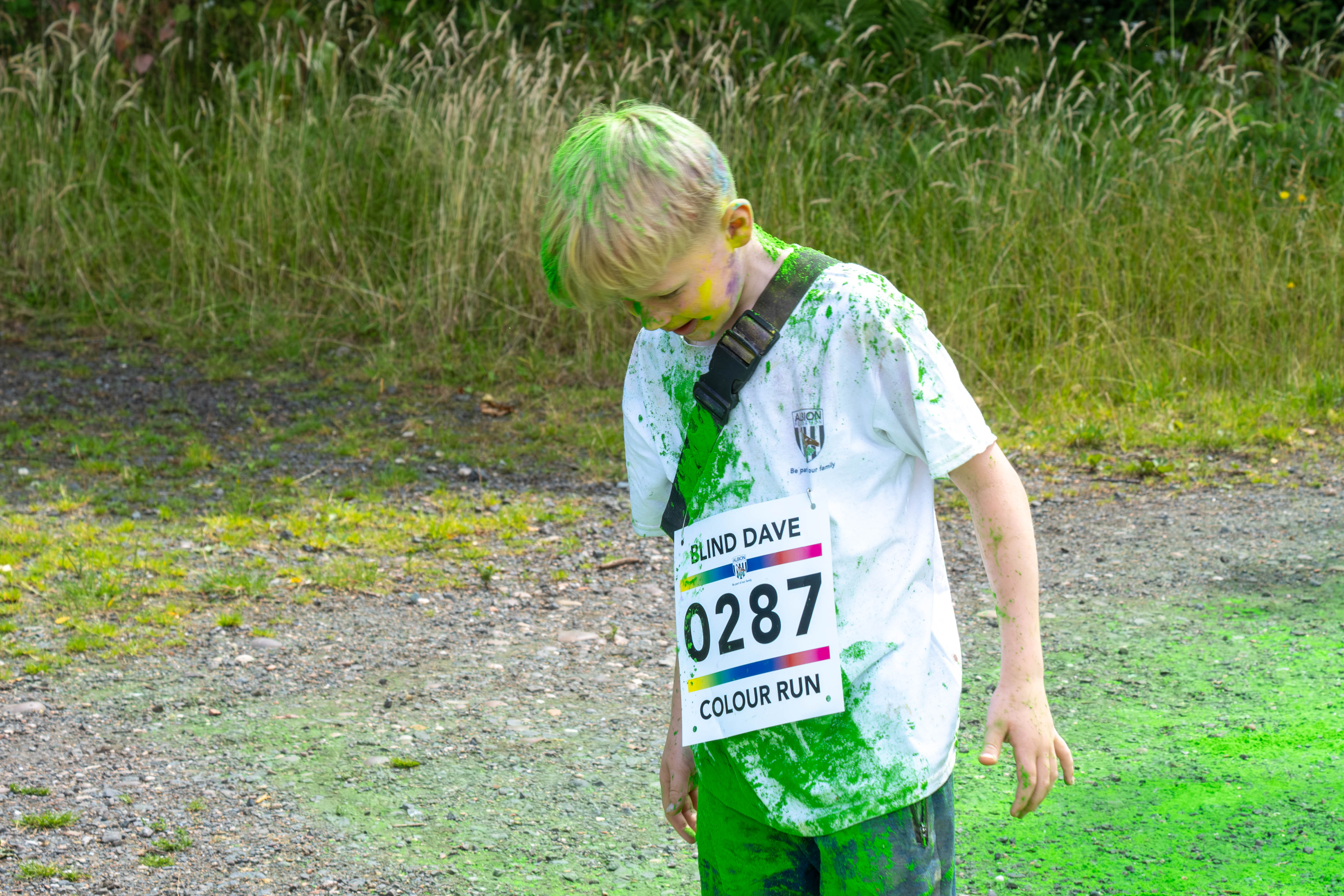 Young participant shaking powder out of his hair.