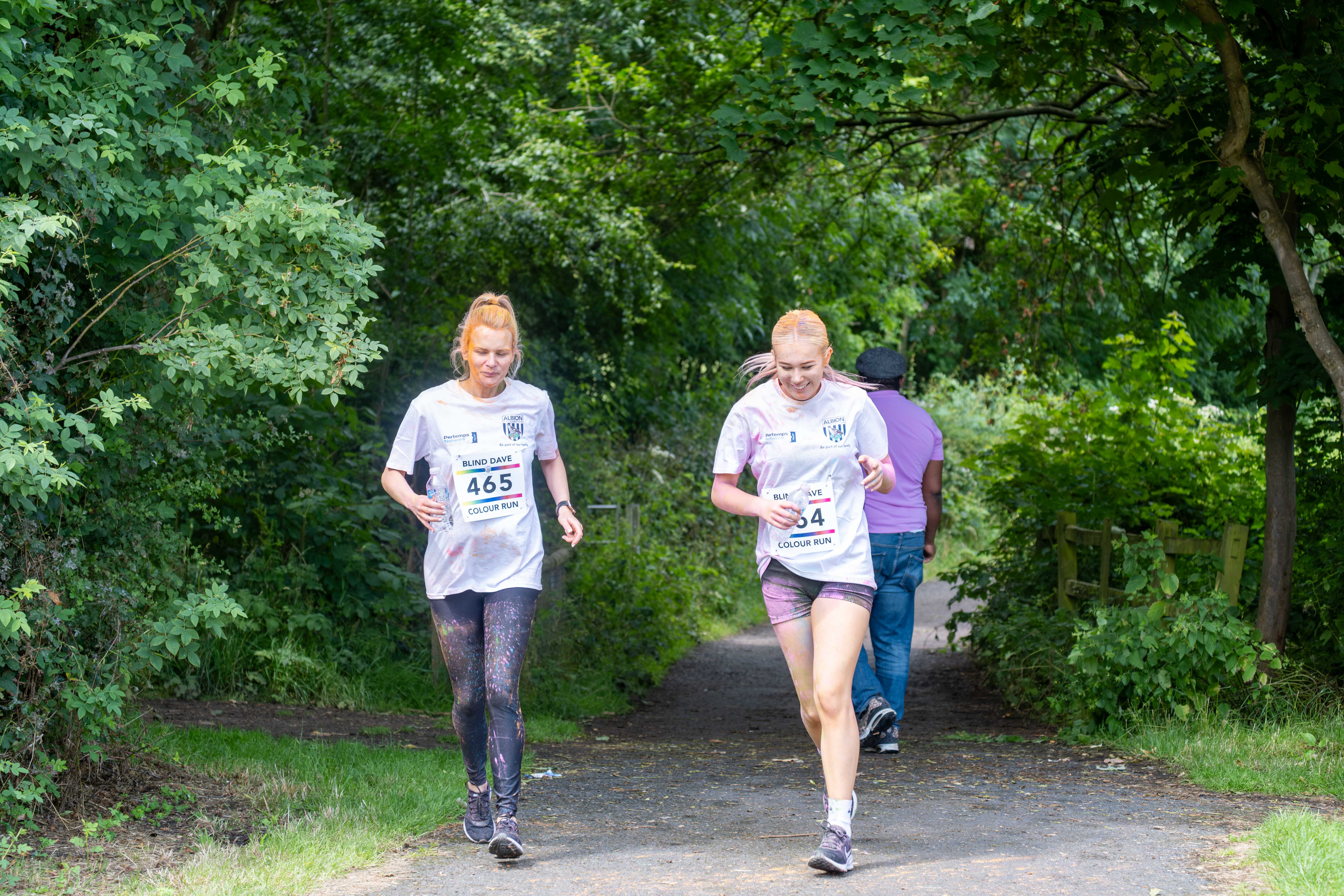 Two runners heading along the path, surround by trees