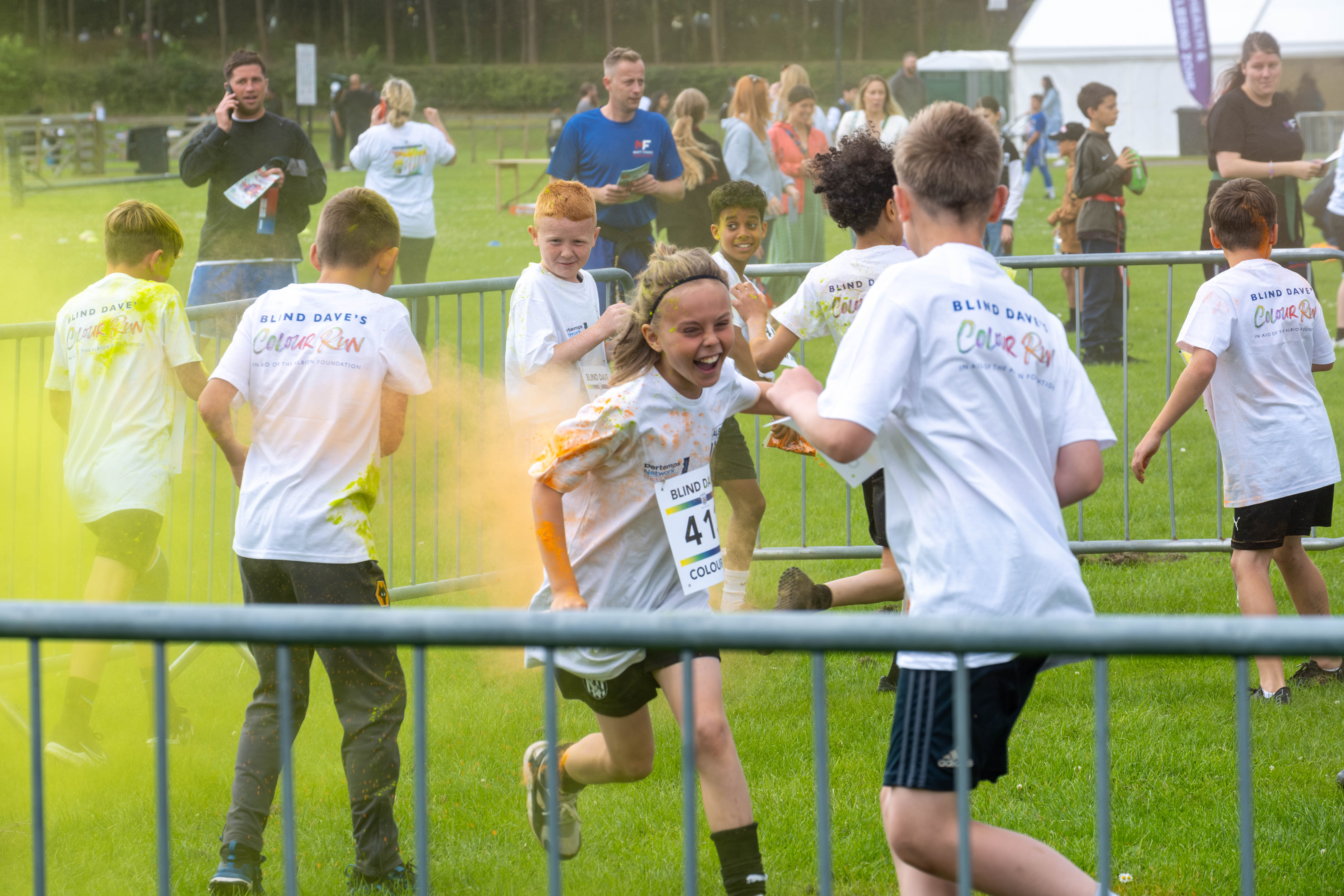 MJPL teammates throwing yellow paint powder.