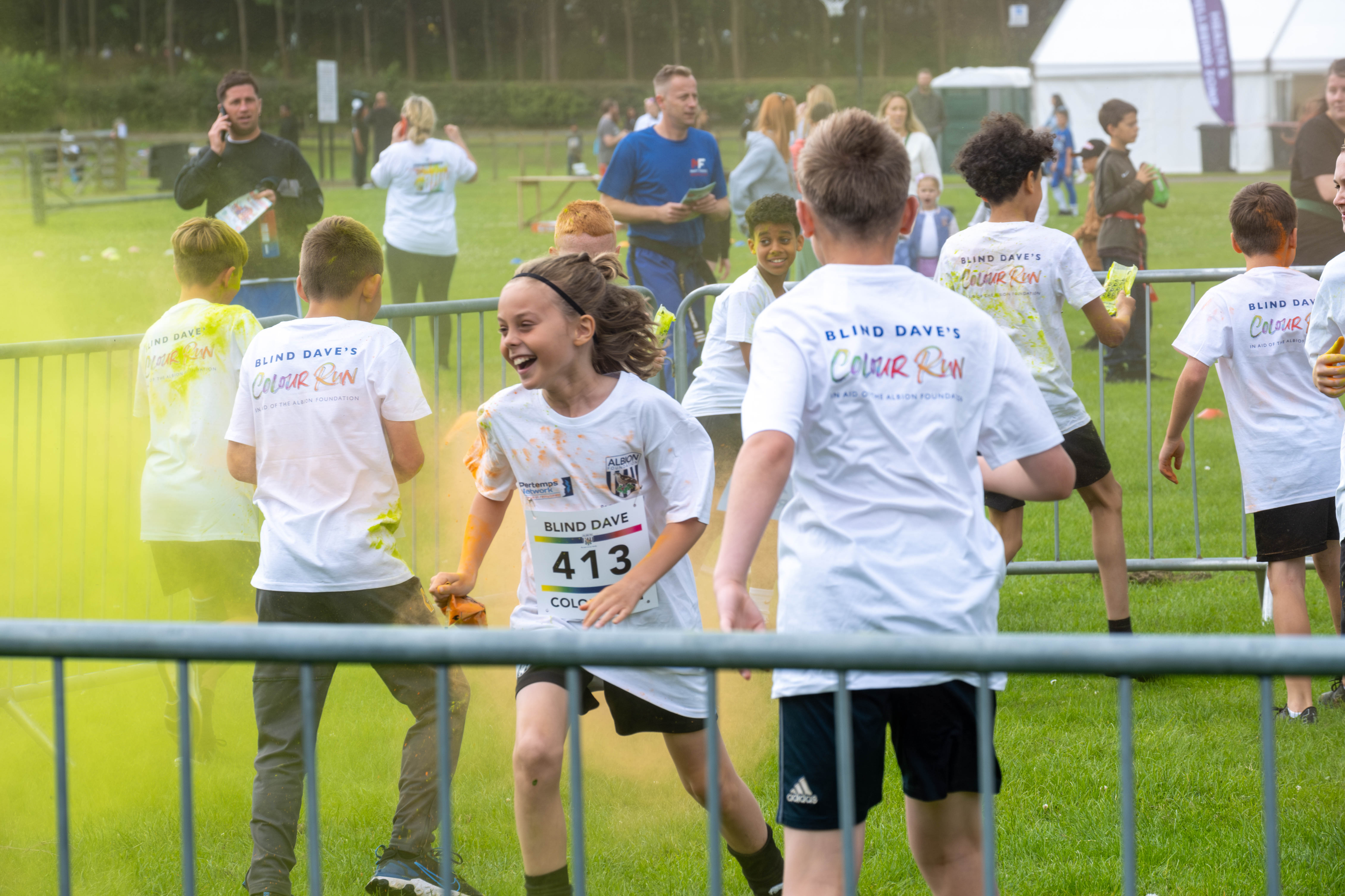 MJPL teammates throwing yellow paint powder.