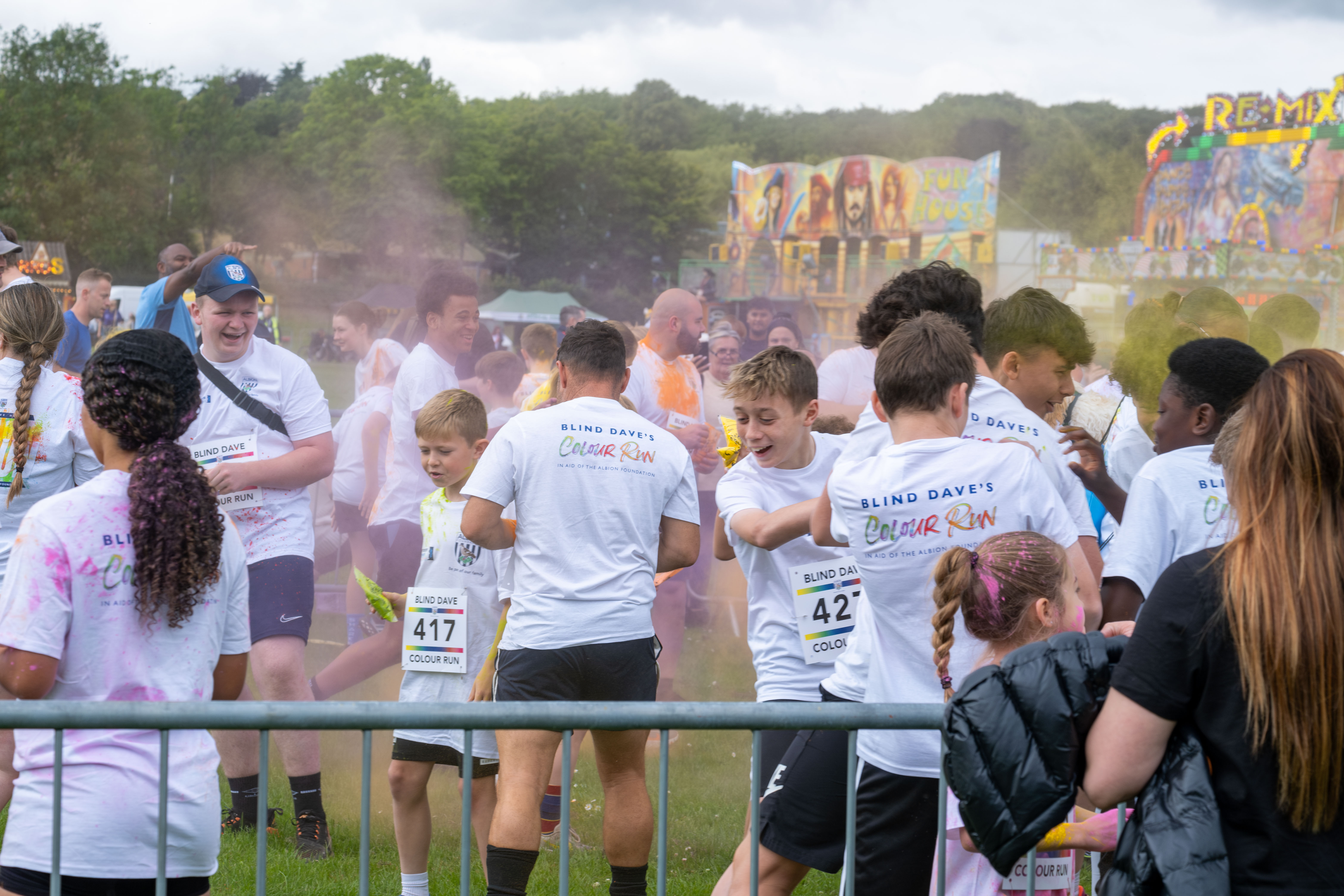 Group of participants inside barrier throwing paint powder.