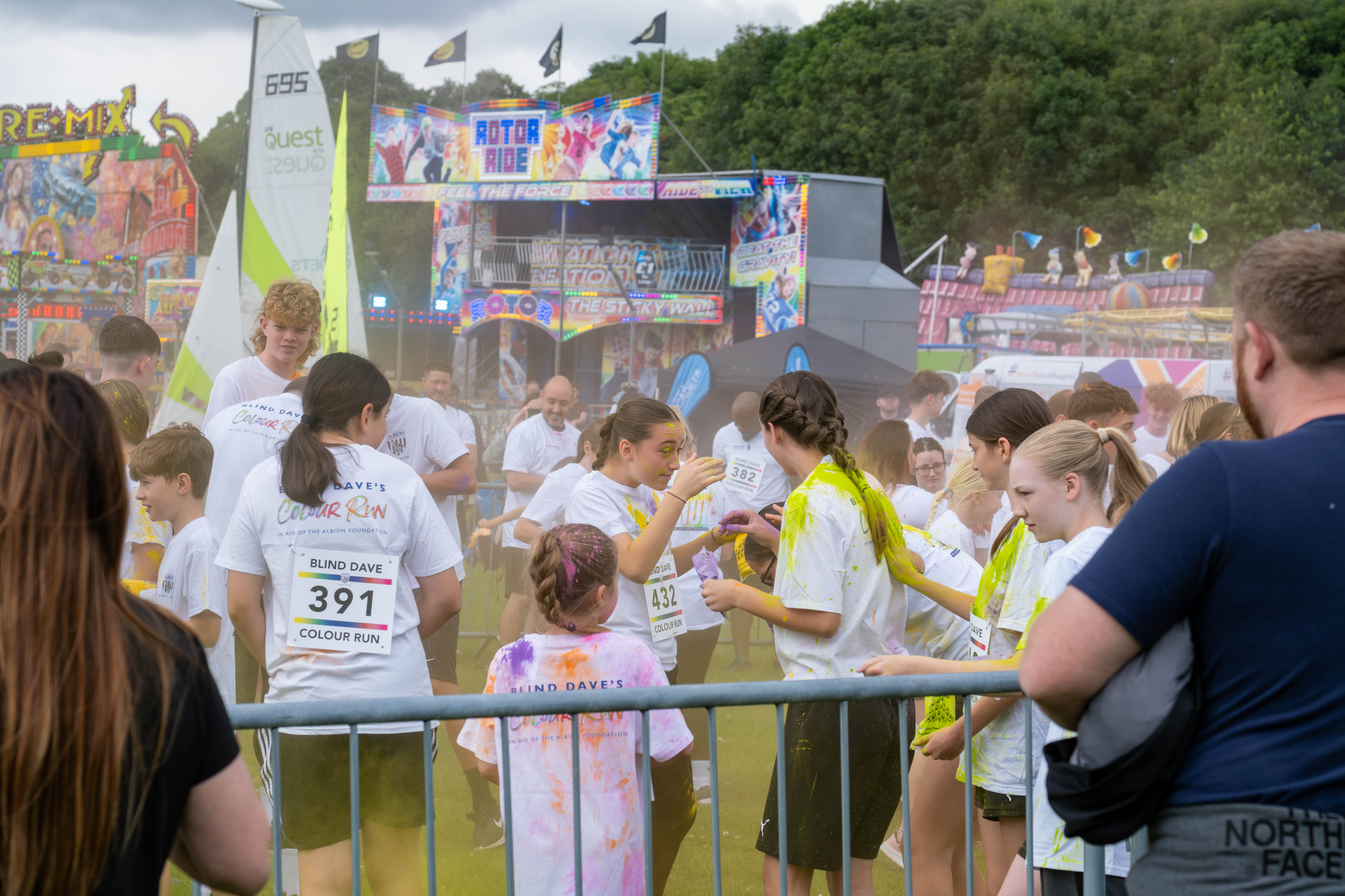 Group of participants inside barrier throwing paint powder.